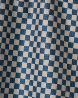 A close-up of the Leopard Lovin tea towel by Geometry shows its stylish blue and white checks, with soft folds and shadows accentuating the practical double-sided design.