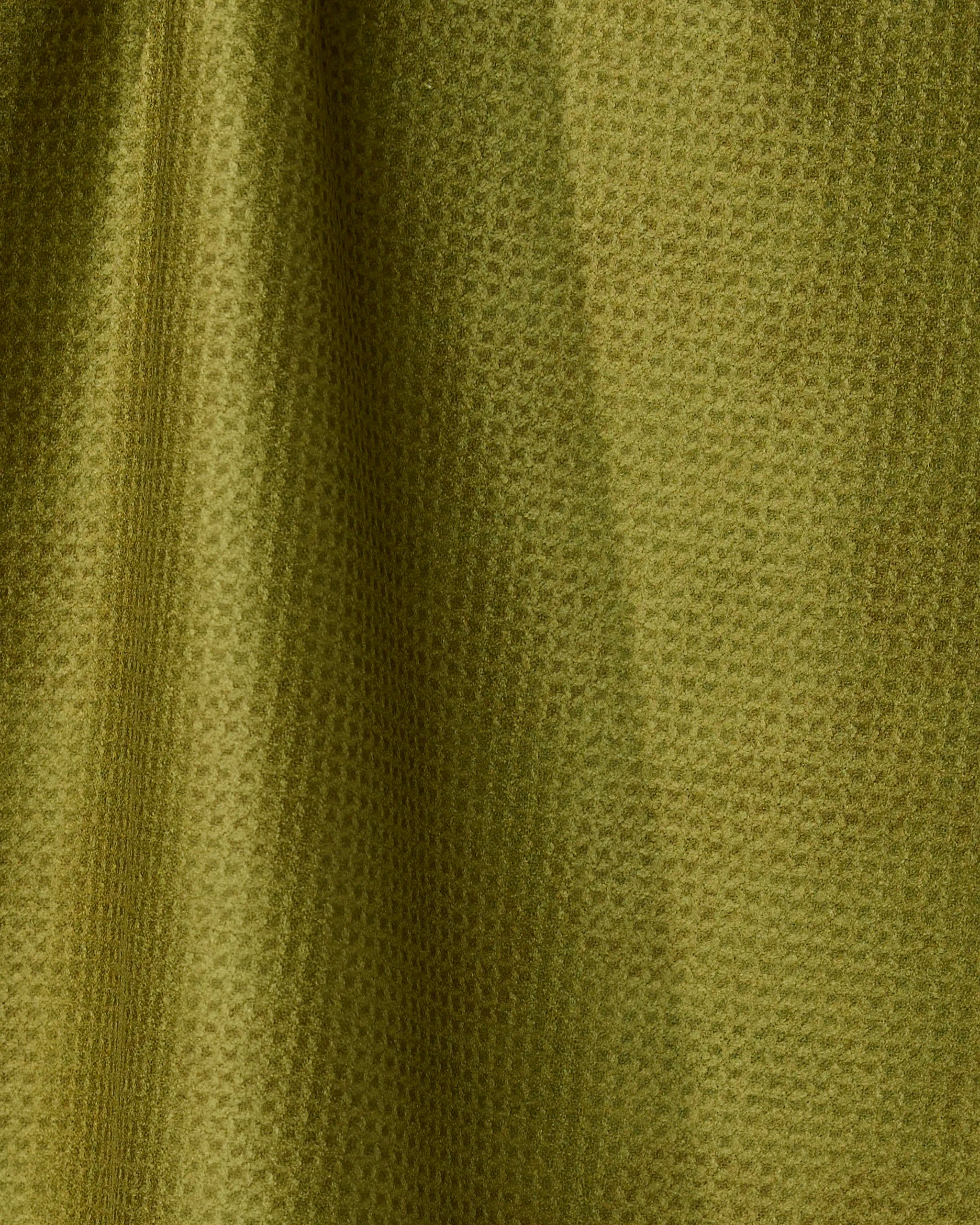 Close-up of Geometry’s Cherry Chic tea towel in olive green, featuring a quick-drying, subtly waffled texture; soft folds and shadows emphasize its stylish, absorbent fabric.