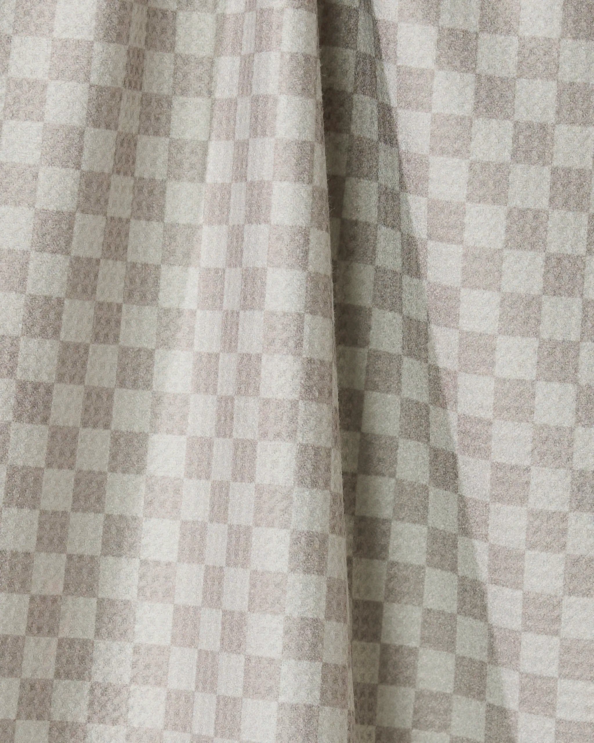 Flamingo Dance by Geometry features light beige and cream checkered drapes made from recycled kitchen towels, with a visible center fold that casts soft shadows and highlights the textured look of the small, even squares.