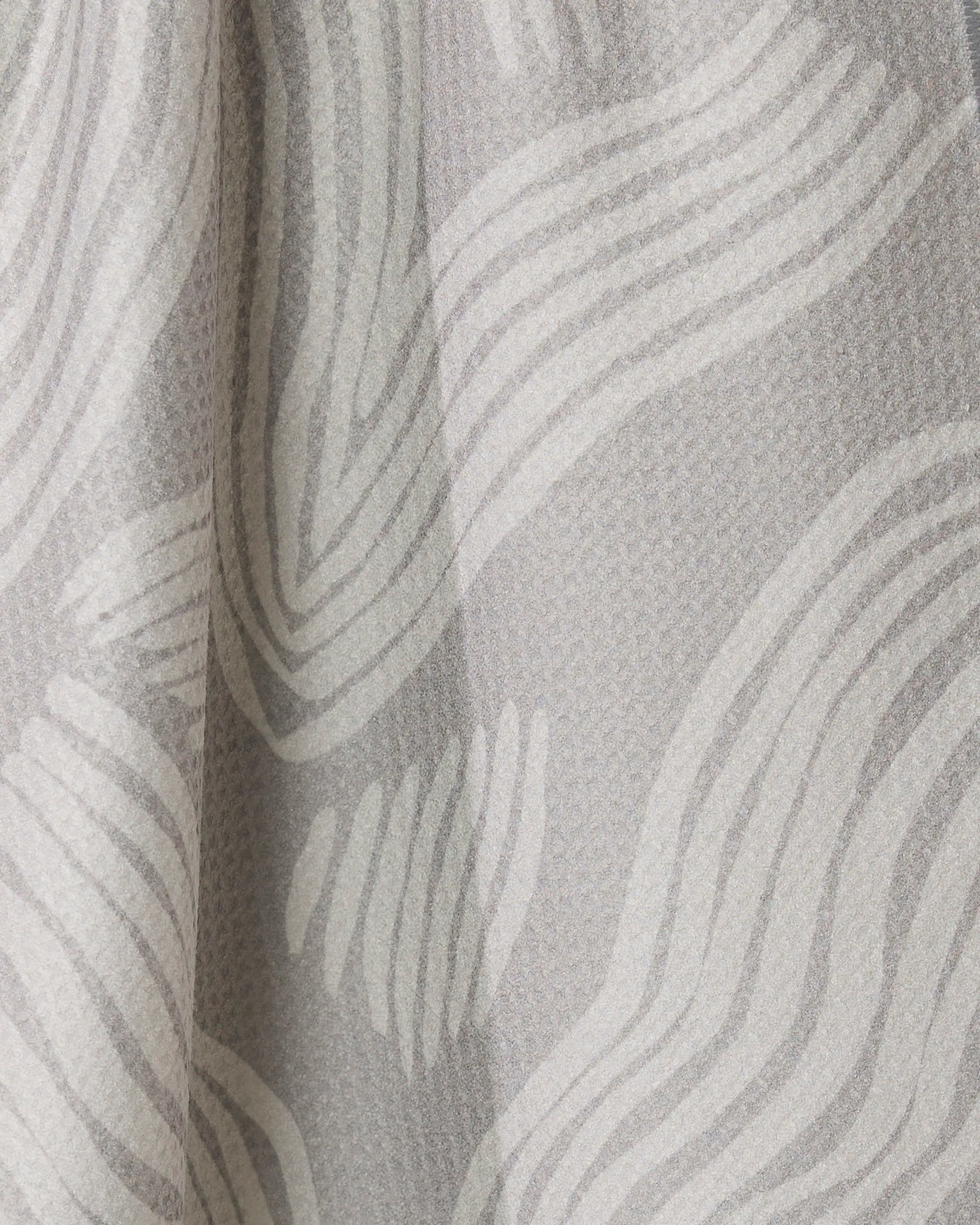 Close-up of Geometrys Stone tea towel in light gray textured fabric with wavy white lines, creating a soft, flowing look. The fabric is draped for added depth and subtle shadow. Quick-drying and stylish for everyday use.