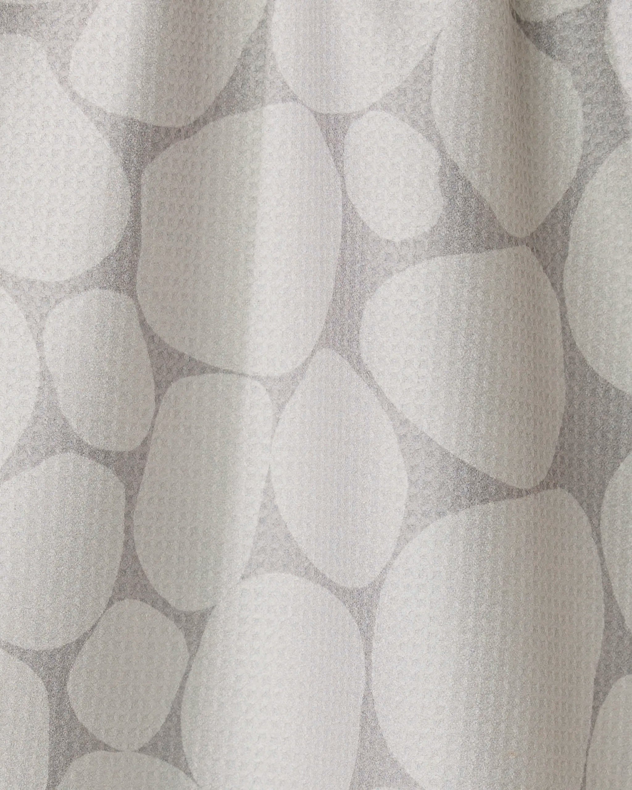 The Geometry Stone curtain is white with a subtle texture and features a light gray pattern of overlapping, irregular ovals and circles—resembling stones or pebbles, inspired by modern recycled kitchen towel designs.
