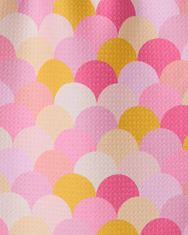 The GEOMETRY Inherit towel features a colorful pattern of overlapping scalloped shapes in pink, yellow, cream, and peach with a textured, ultra-absorbent surface—resembling fish scales or a mermaid tail.