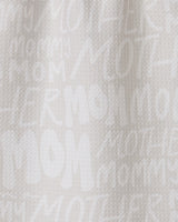 The GEOMETRY Mom bar towel is crafted from recycled white textured fabric, featuring “MOM,” “MOTHER,” and “MOMMY” in varied fonts and sizes printed subtly across its surface.