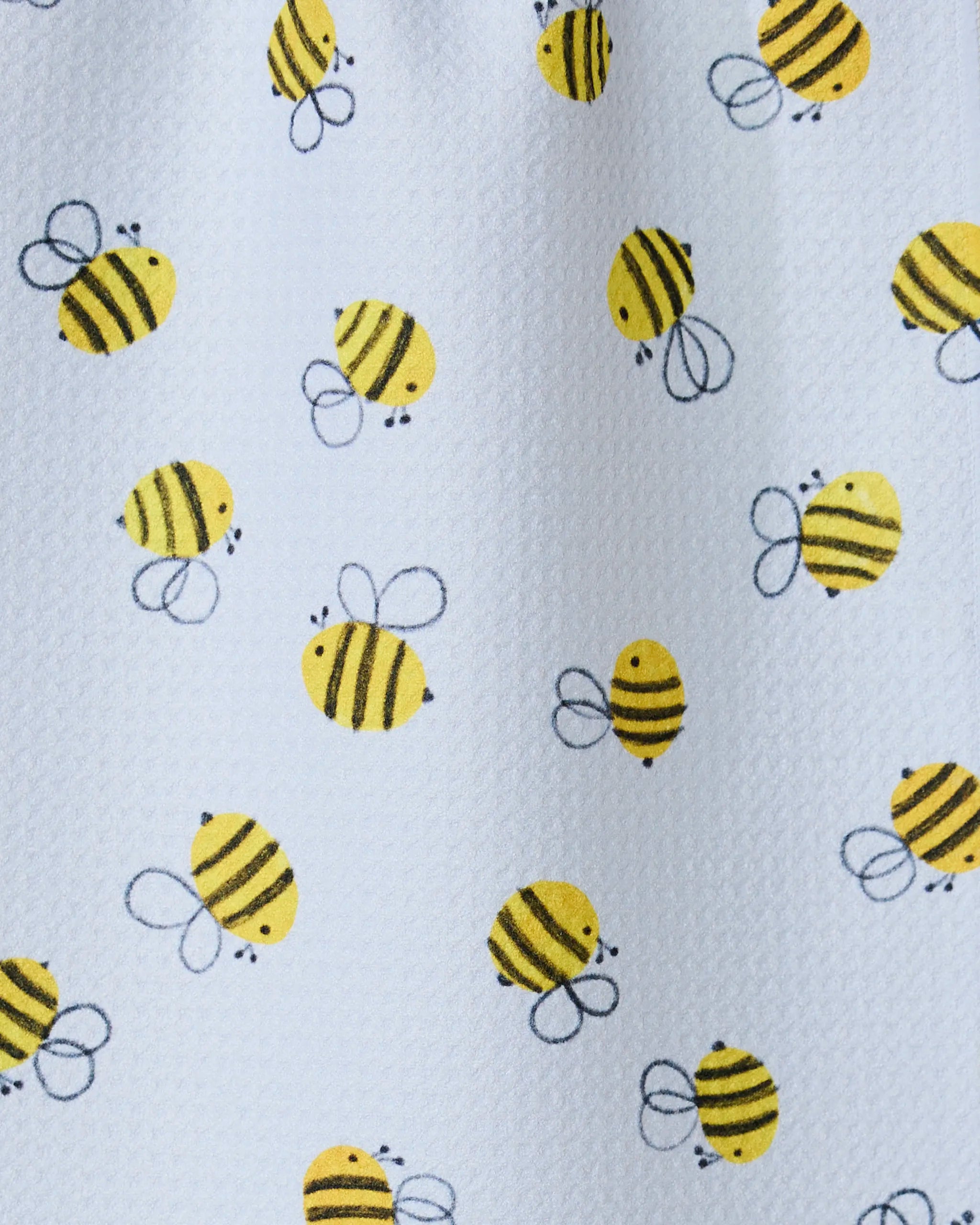 Buzzing by GEOMETRY features a playful pattern of cartoon yellow bees on a white textured background, ideal for an ultra-absorbent towel or bar towel crafted from recycled materials.