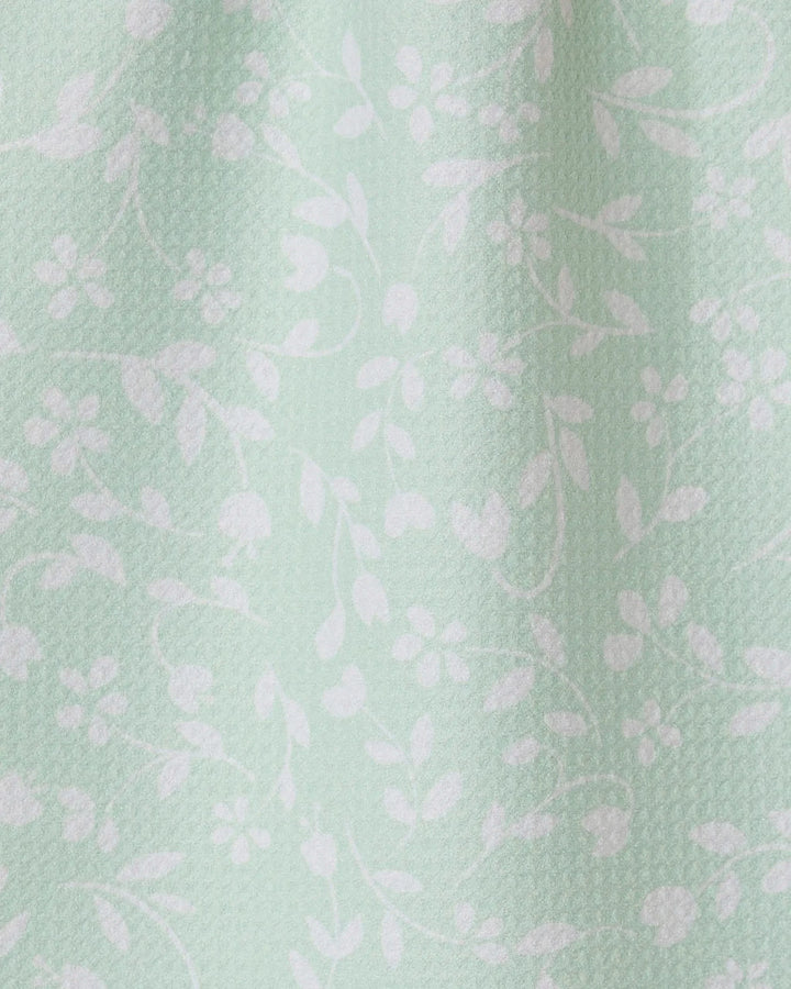 The Dandy towel by GEOMETRY features light mint green fabric with a subtle texture and delicate white floral vine pattern. Ultra-absorbent, it drapes softly for an elegant, functional touch in your space.