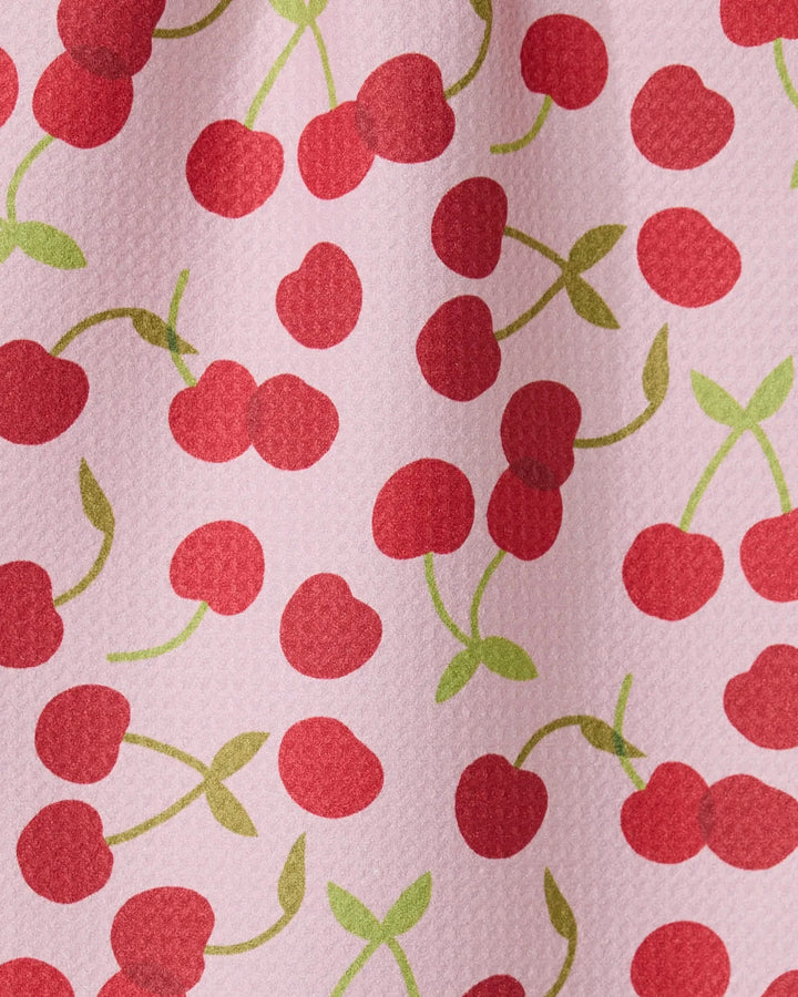 The GEOMETRY Cheery Cherries bar towel features a pink textured design with red cherries and green stems, made from recycled materials for an eco-friendly and ultra-absorbent option.