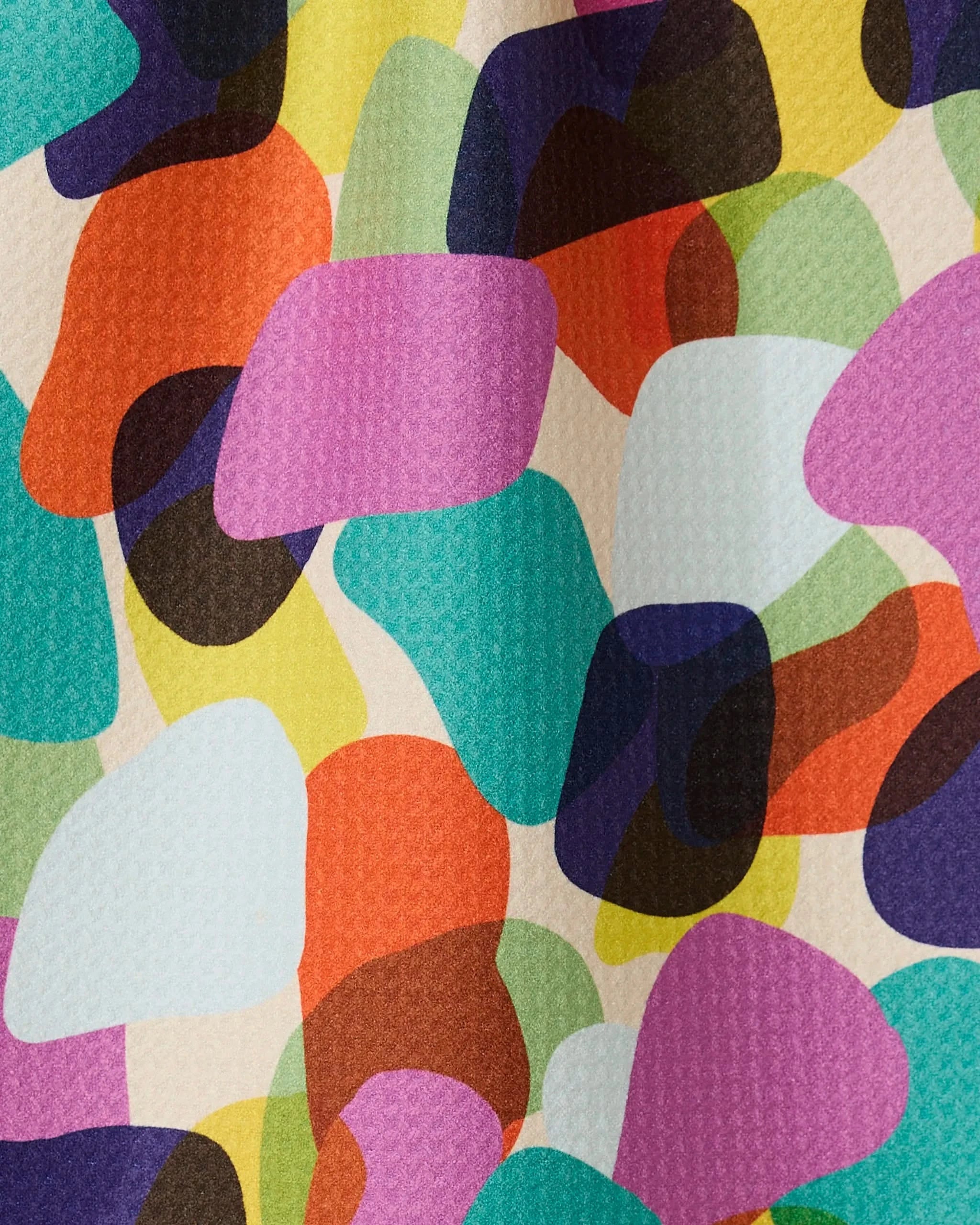 Colorful Pebbles by GEOMETRY features vibrant, overlapping abstract shapes on a textured white background—ideal for a bar towel made from recycled materials.