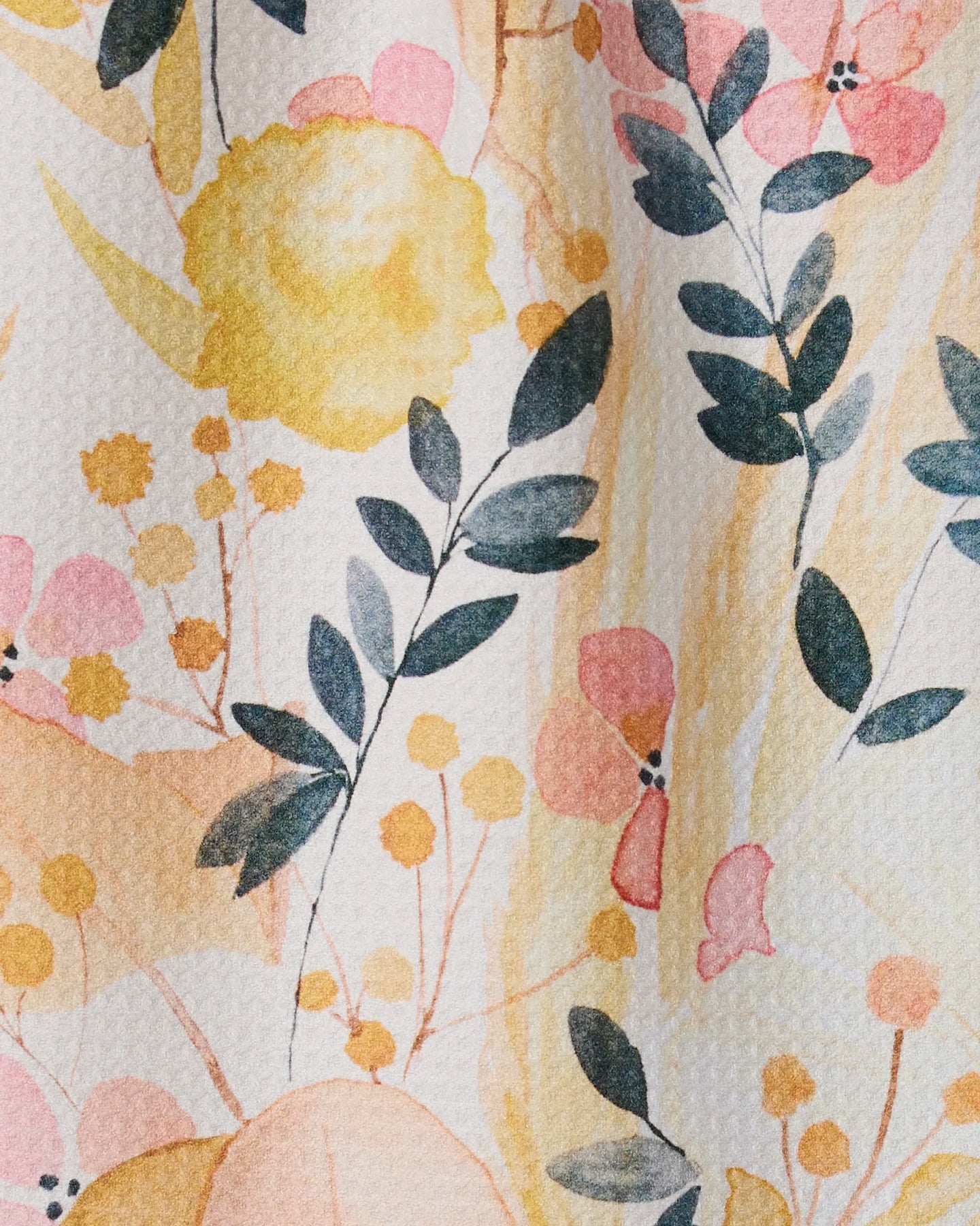 Sleepy Fields by GEOMETRY features pastel flowers and green leaves in soft yellow, pink, and peach on textured paper—an eco-friendly design inspired by recycled materials and the feel of an ultra-absorbent towel.
