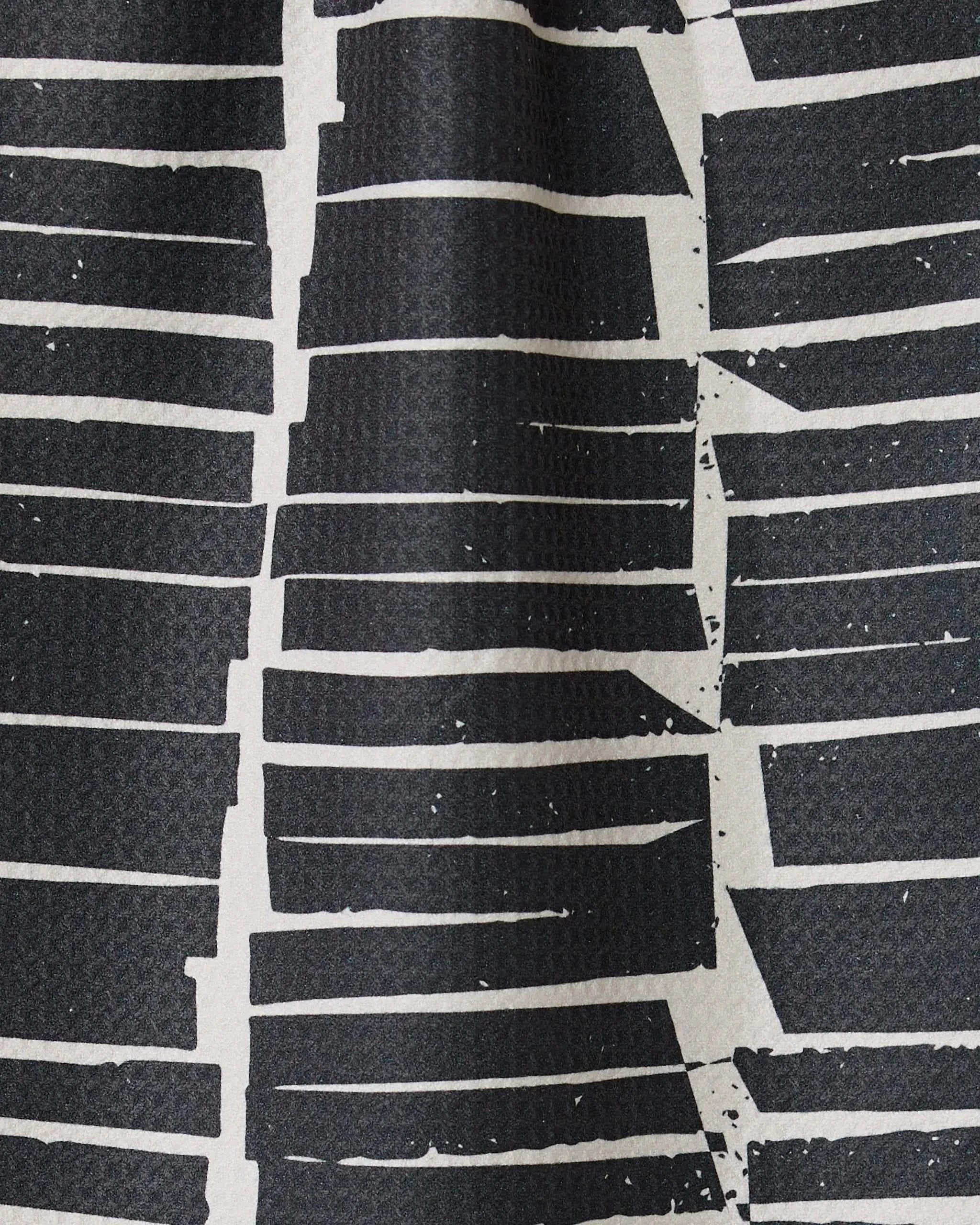 Tall Stacks by GEOMETRY features an abstract black and white pattern of irregular, horizontal lines with jagged edges—perfect for a bar towel made from recycled materials.