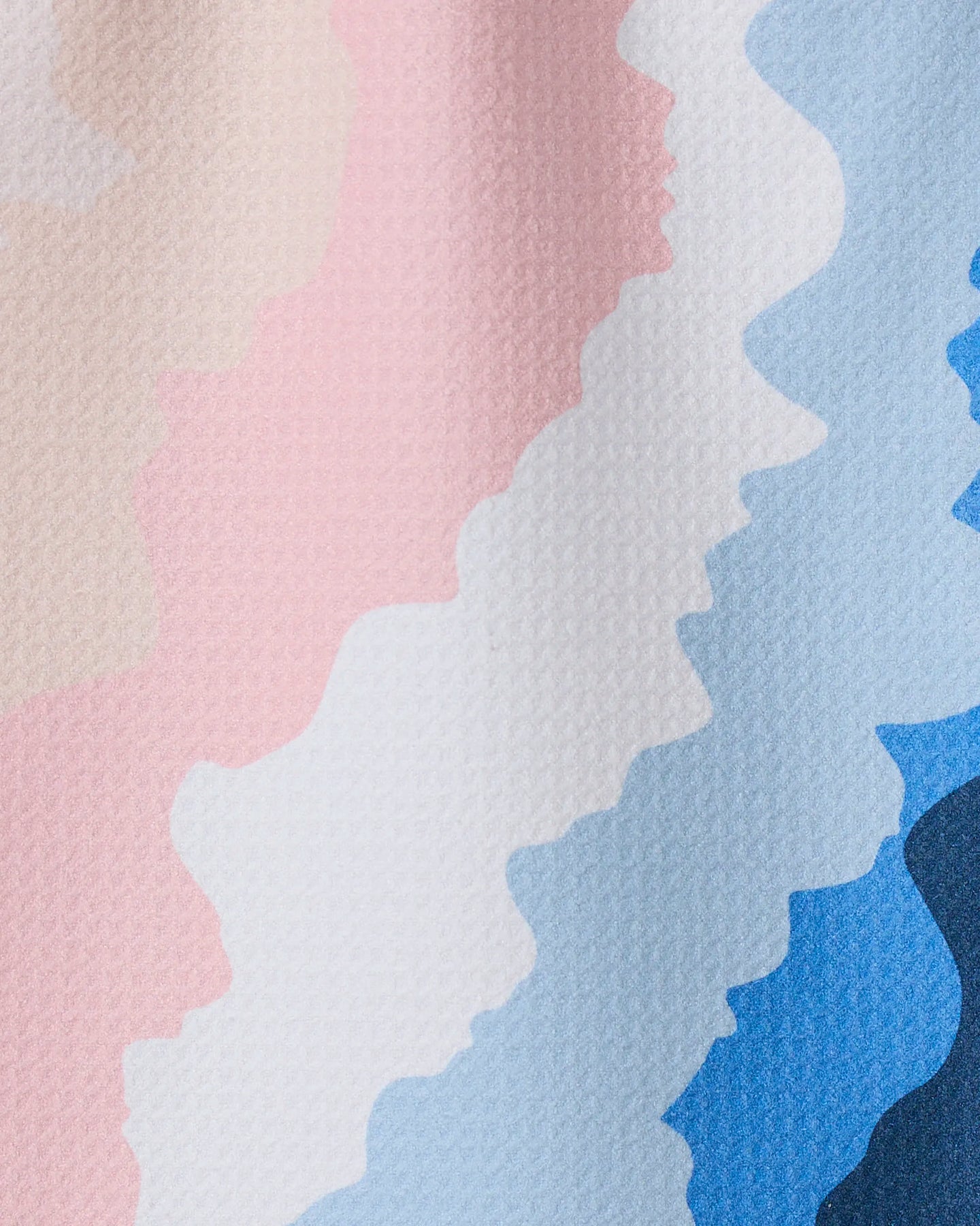GEOMETRY’s “Shore” features wavy, horizontal stripes in pastel pink, cream, white, light blue, and blue on a lightly textured surface, with colors blending softly in a zigzag pattern reminiscent of recycled kitchen towels.