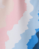 GEOMETRY’s “Shore” features wavy, horizontal stripes in pastel pink, cream, white, light blue, and blue on a lightly textured surface, with colors blending softly in a zigzag pattern reminiscent of recycled kitchen towels.