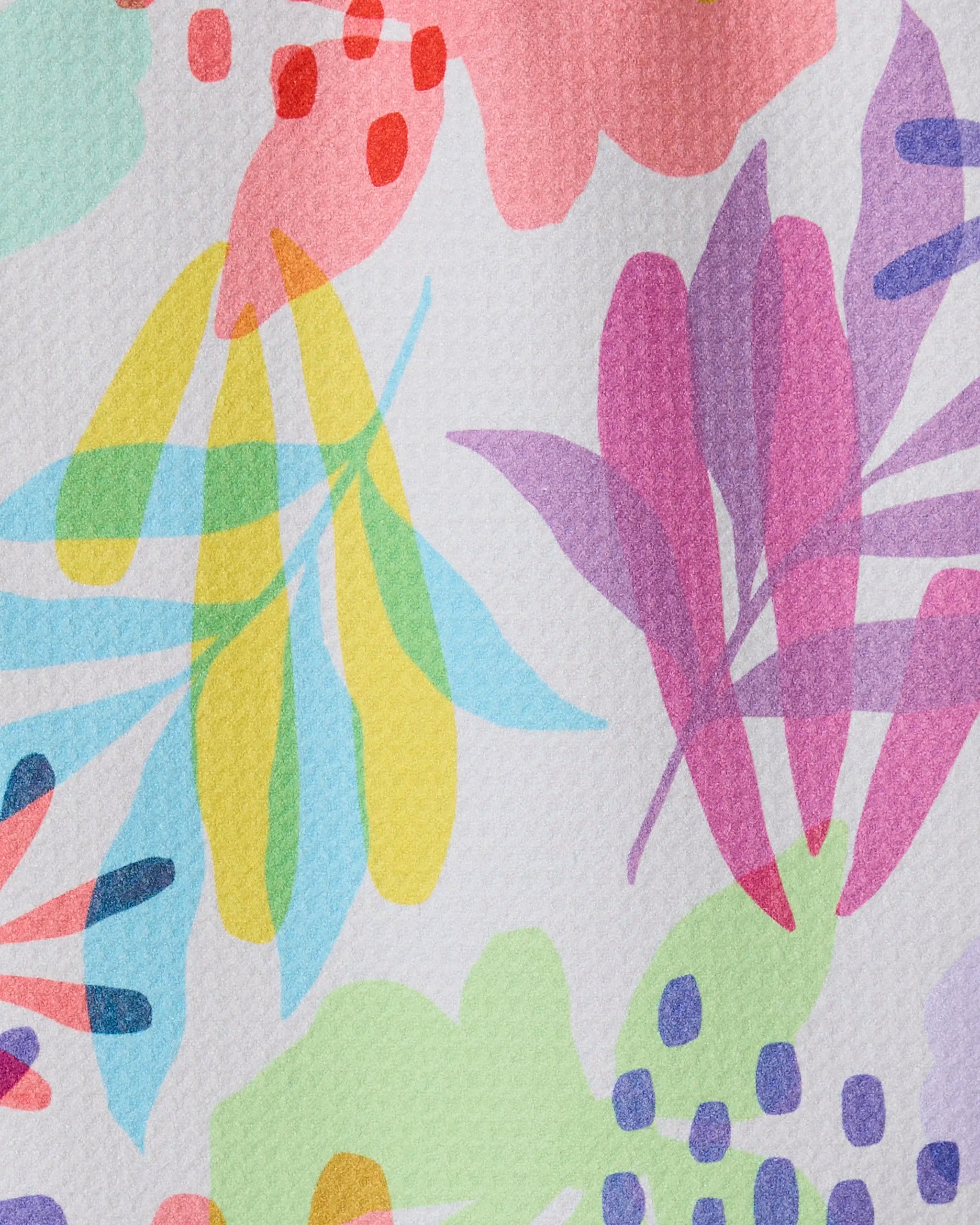 Botanical Burst by GEOMETRY features a vibrant abstract floral pattern with overlapping leaves and flowers in pink, yellow, green, blue, and purple on a textured white base. Made from recycled materials for a sustainable, ultra-absorbent towel.