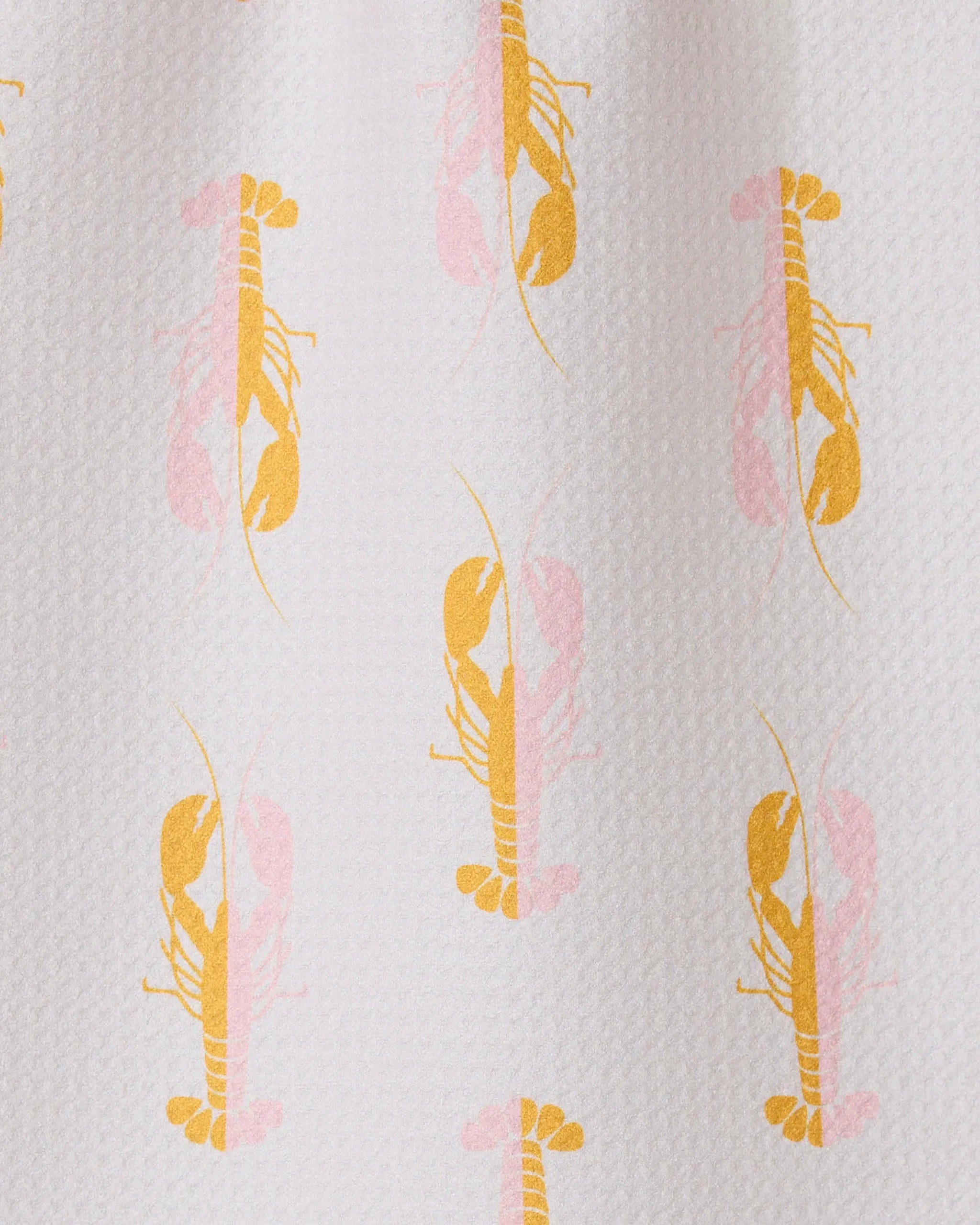 The GEOMETRY Lobster Love bar towel is textured white, made from recycled materials, and features a playful repeat pattern of yellow and light pink lobsters facing both up and down in alternating rows.