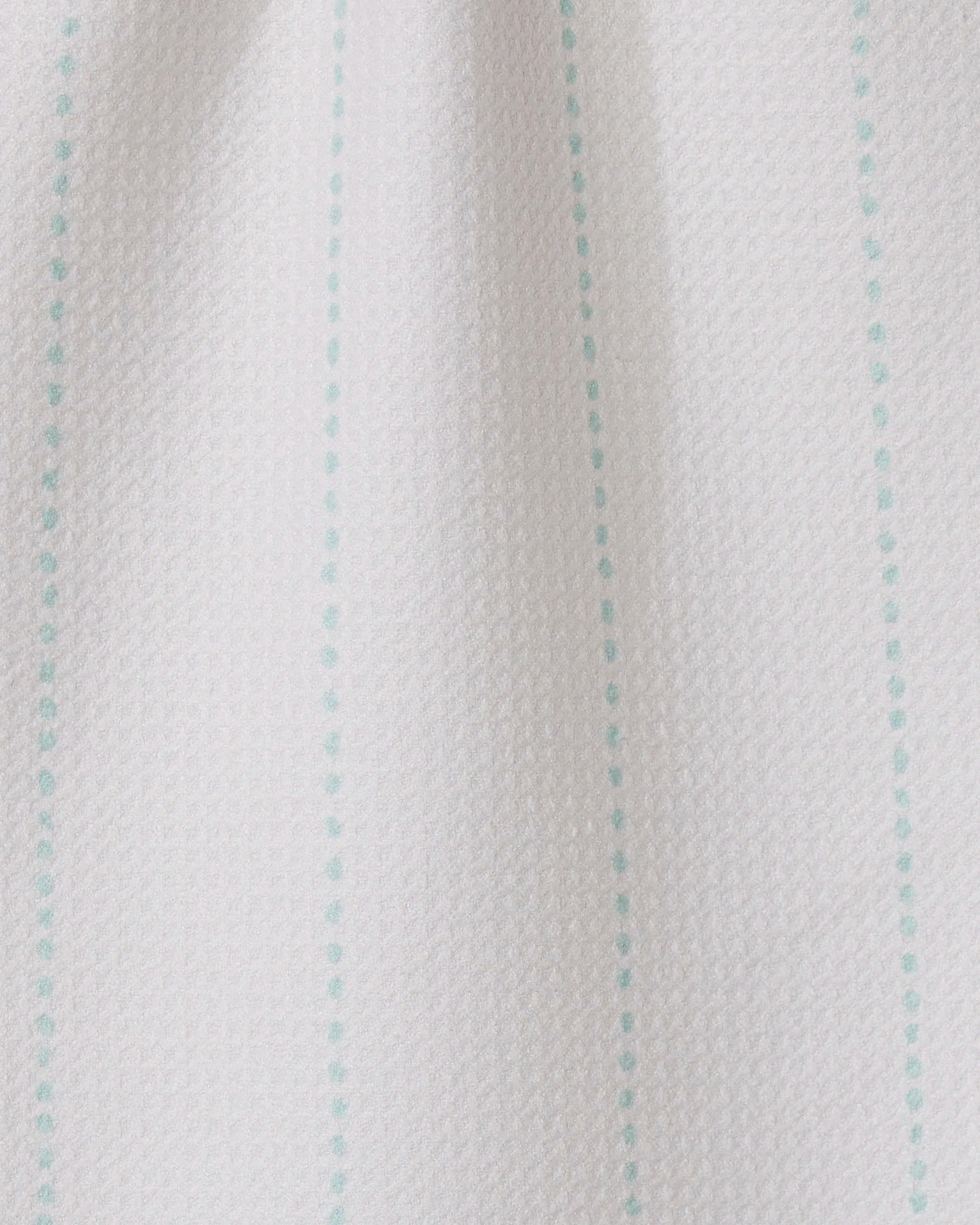 Close-up of GEOMETRY’s Dotted Dunes: white textured fabric featuring evenly spaced turquoise vertical dotted lines—a minimal, simple design perfect for ultra-absorbent towels made from recycled materials.