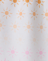 Fun in the Sun by GEOMETRY features rows of small sun patterns, orange fading to pink on textured white—ideal for inspiring an ultra-absorbent towel made from recycled materials.