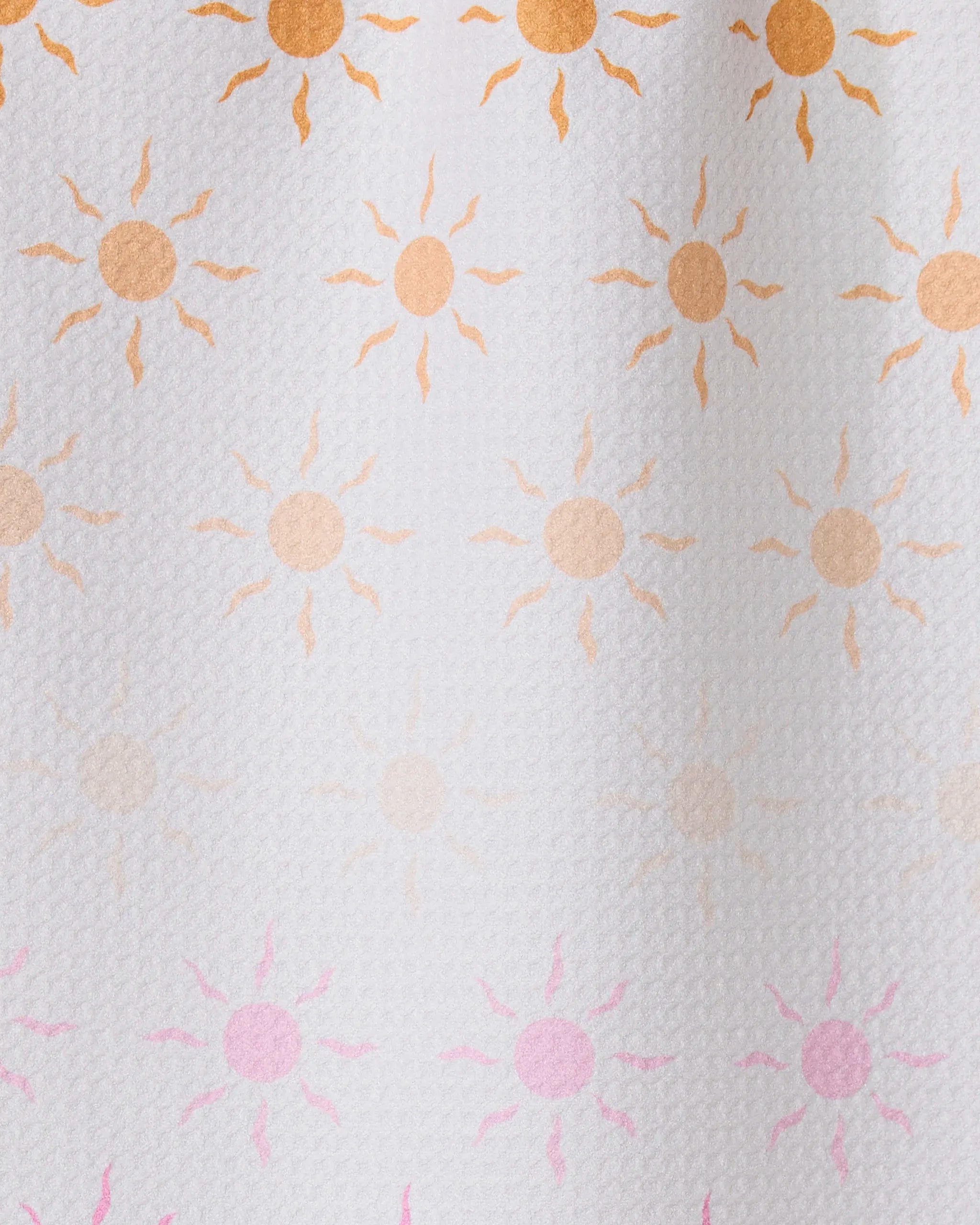Fun in the Sun by GEOMETRY features rows of small sun patterns, orange fading to pink on textured white—ideal for inspiring an ultra-absorbent towel made from recycled materials.