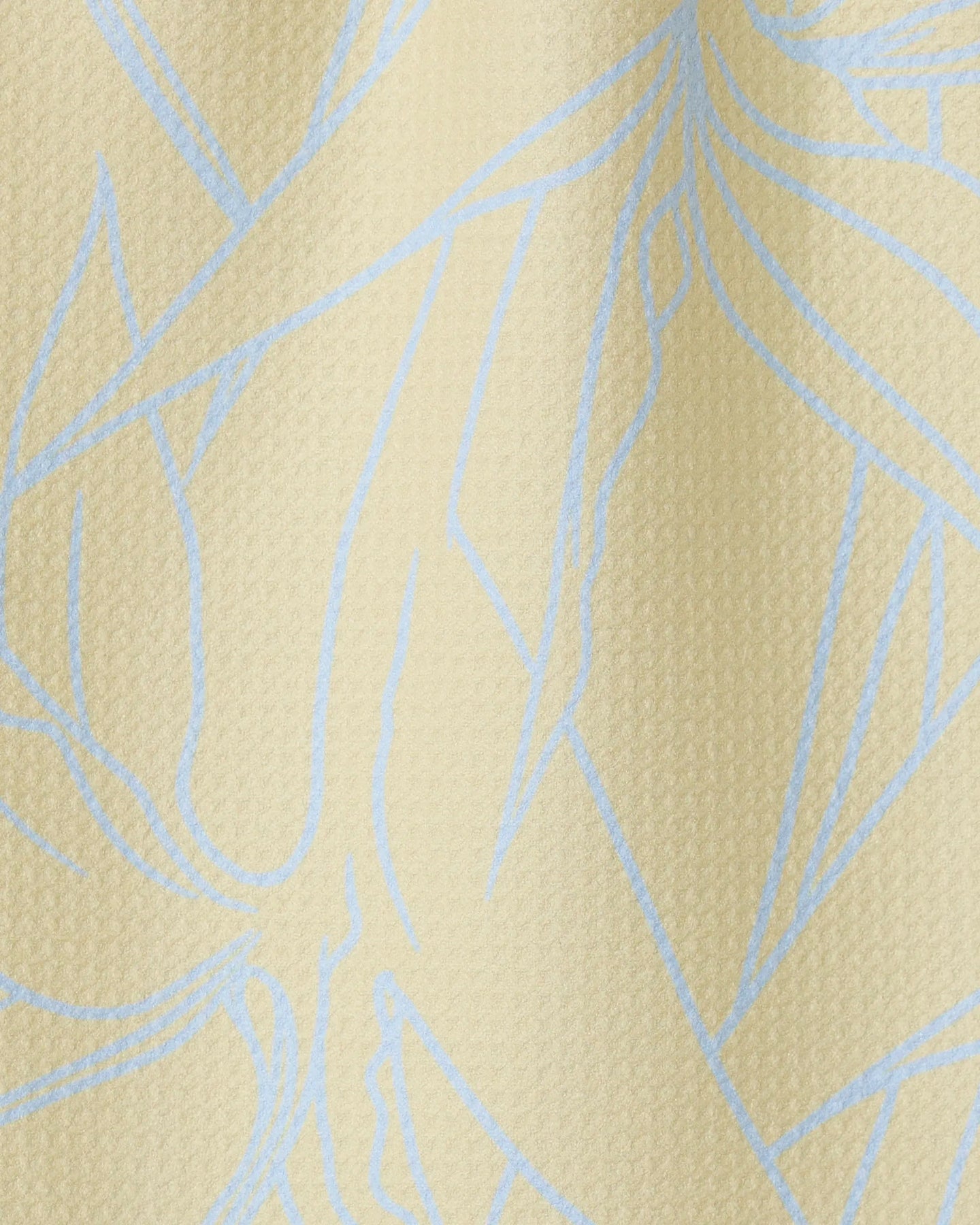 Close-up of Paradise Blooms by GEOMETRY—a textured, light beige towel featuring abstract blue lines. The ultra-absorbent, wavy surface with subtle shadows highlights its soft, high-quality fabric.