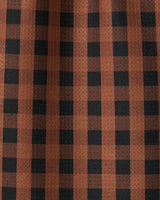 Close-up of GEOMETRYs Fall Gingham bar towel, featuring a brown and black checkered pattern. The ultra-absorbent fabric has gentle folds and subtle shadows, with vertical and horizontal stripes forming classic squares.