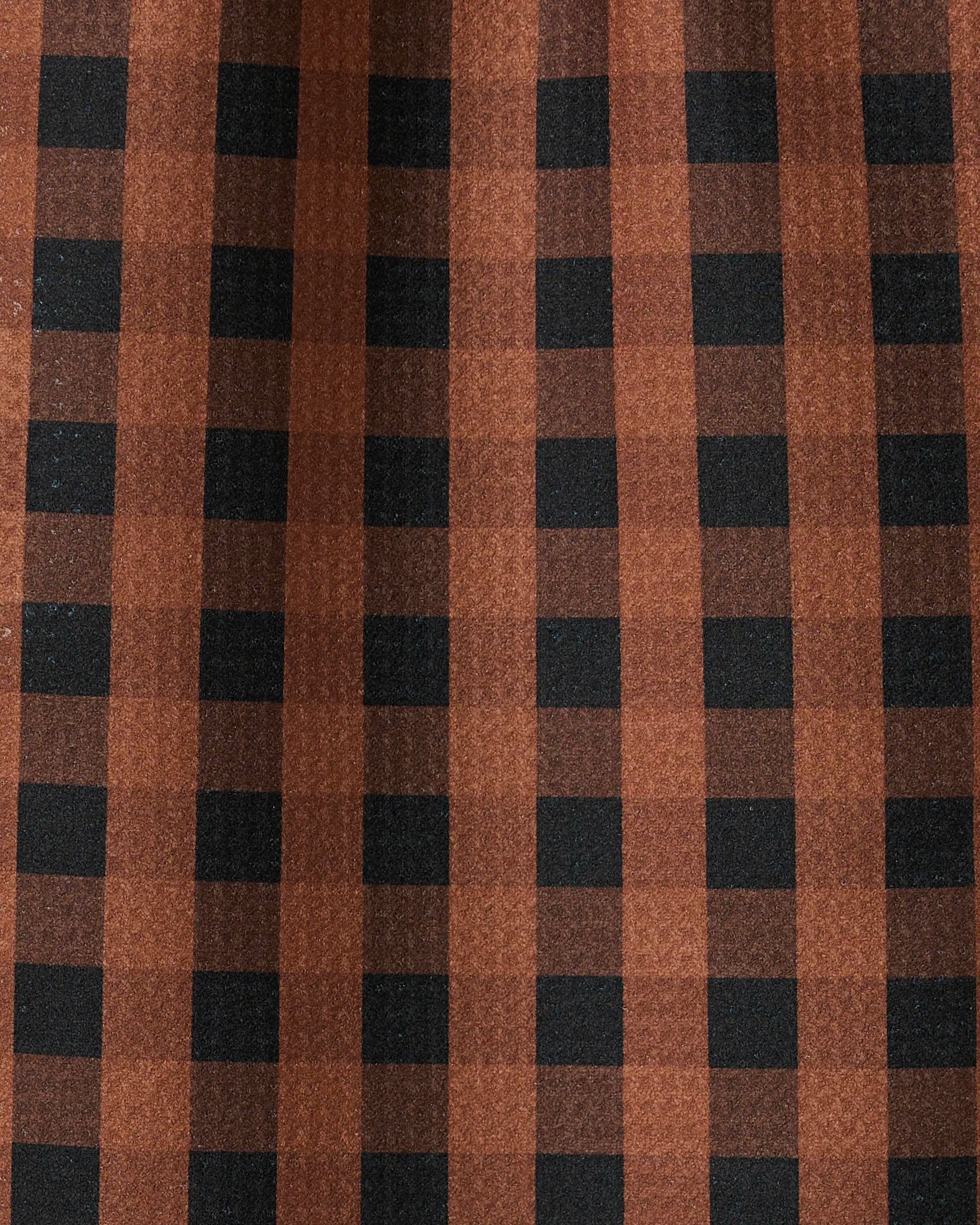 Close-up of GEOMETRYs Fall Gingham bar towel, featuring a brown and black checkered pattern. The ultra-absorbent fabric has gentle folds and subtle shadows, with vertical and horizontal stripes forming classic squares.