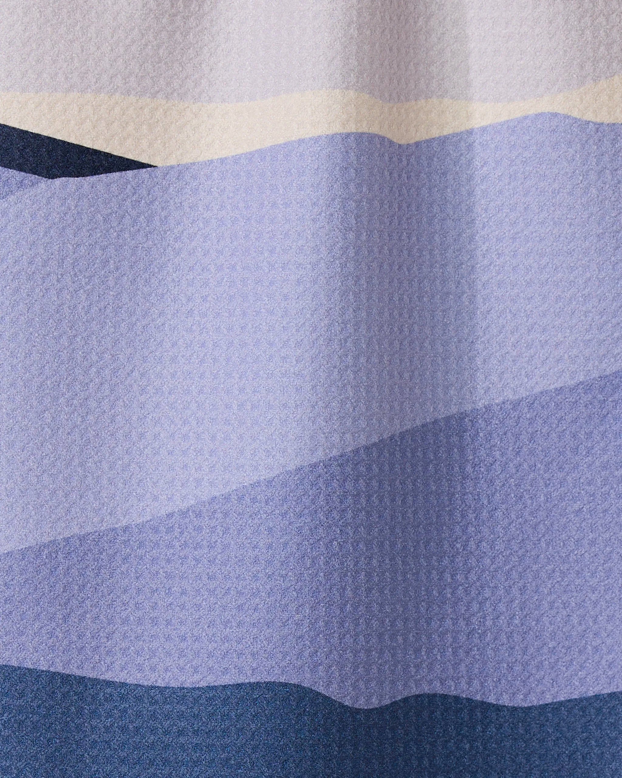 Mountainous by GEOMETRY showcases wavy blue, lavender, and cream bands resembling layered hills, with a subtle dimpled texture inspired by ultra-absorbent towel designs.
