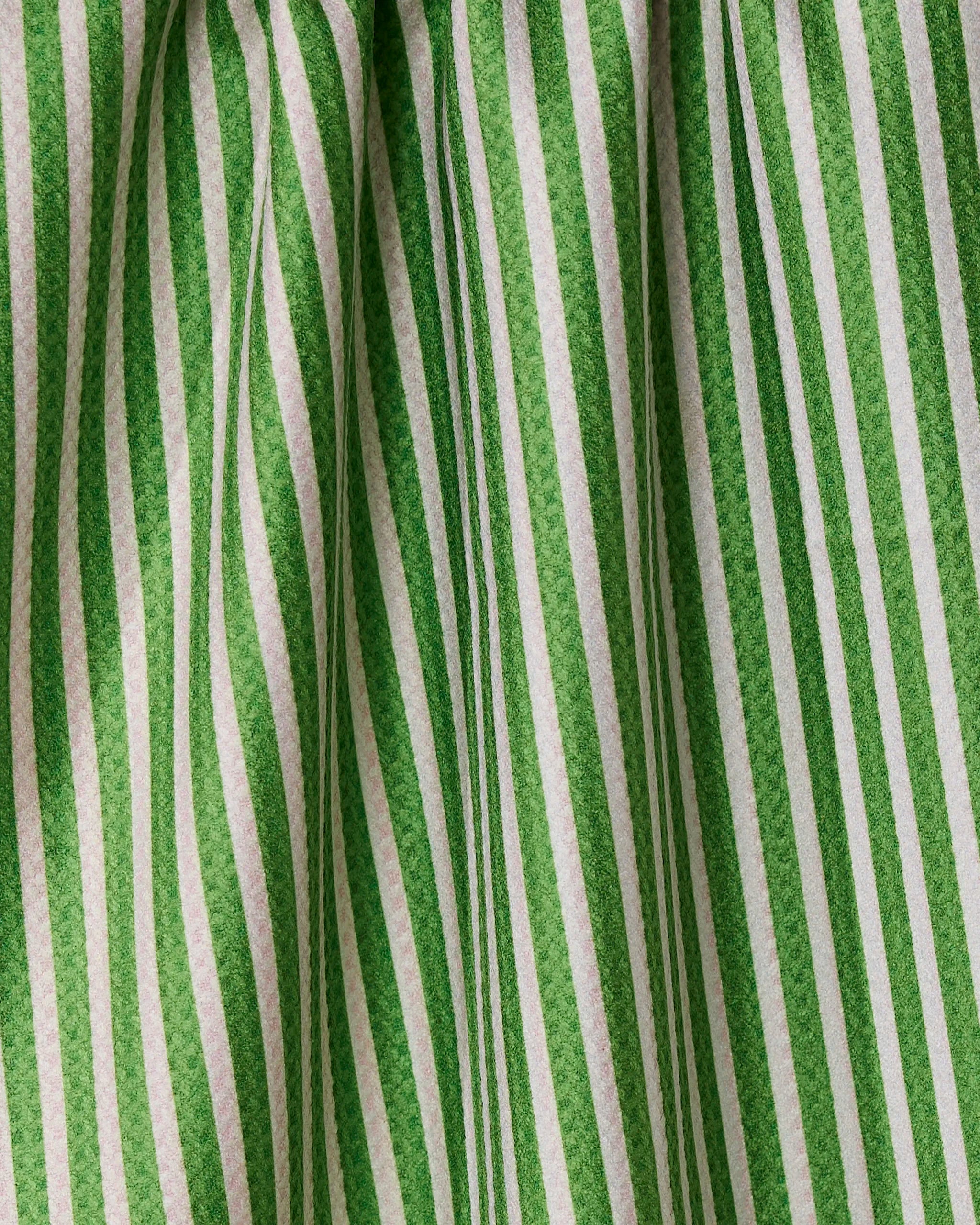 Red and green vertical striped fabric with soft folds and shadows creates a textured look—this double-sided Geometry Red And Green tea towel brings both style and function to your kitchen.
