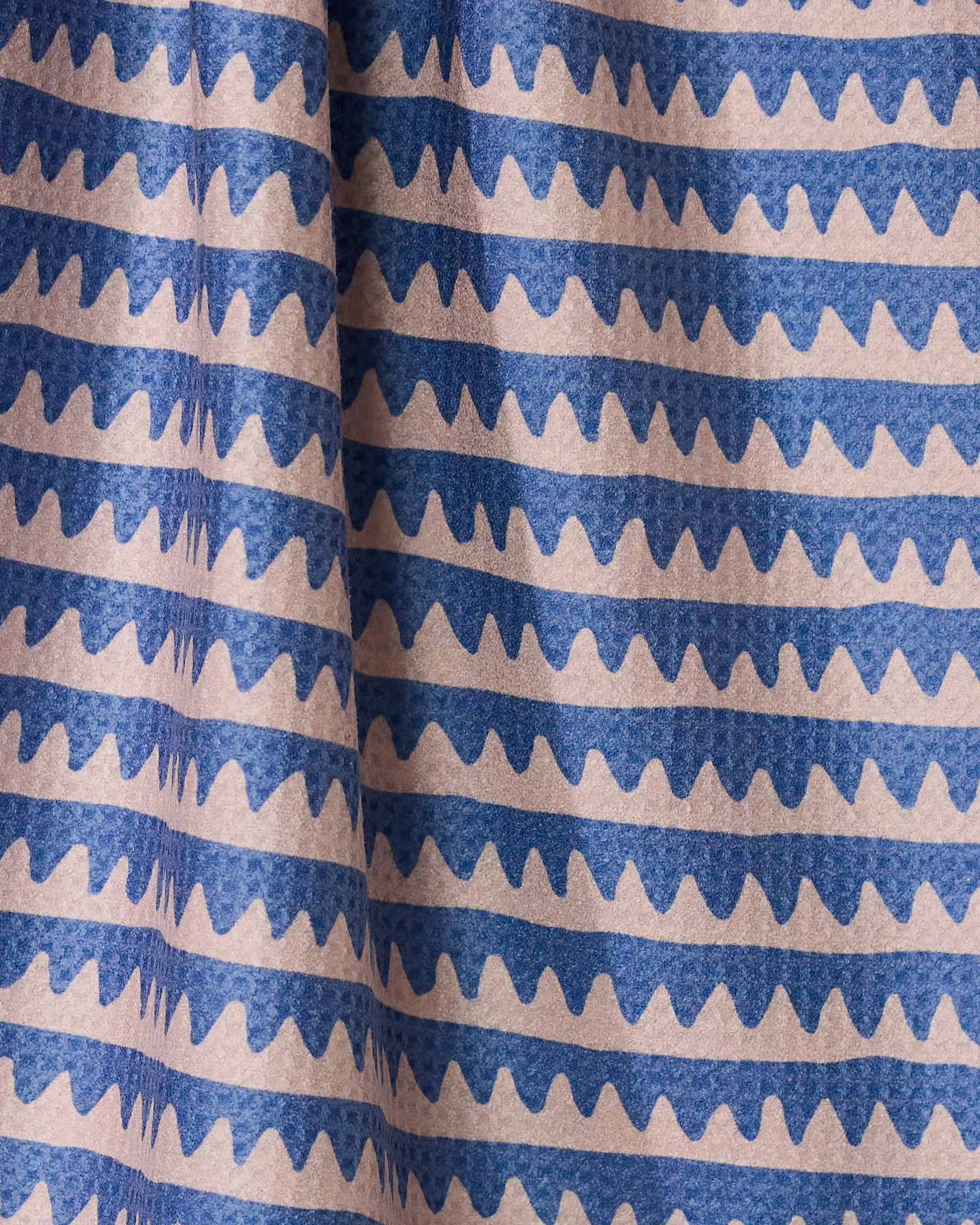 The Geometry Lav tea towel features quick-drying fabric with evenly spaced horizontal wavy blue lines on a light beige background, combining style and practicality for everyday use.