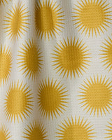 Radiating yellow suns repeat across a textured white fabric, giving depth and shadow to Geometry’s Energize absorbent quick-dry towel—perfect for brightening your kitchen.