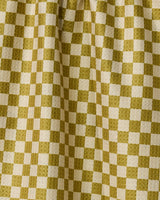 The Zebra Way by Geometry features yellow and cream checkered fabric with soft folds and depth. This double-sided tea towel is both stylish and practical, making it a perfect addition to your kitchen.