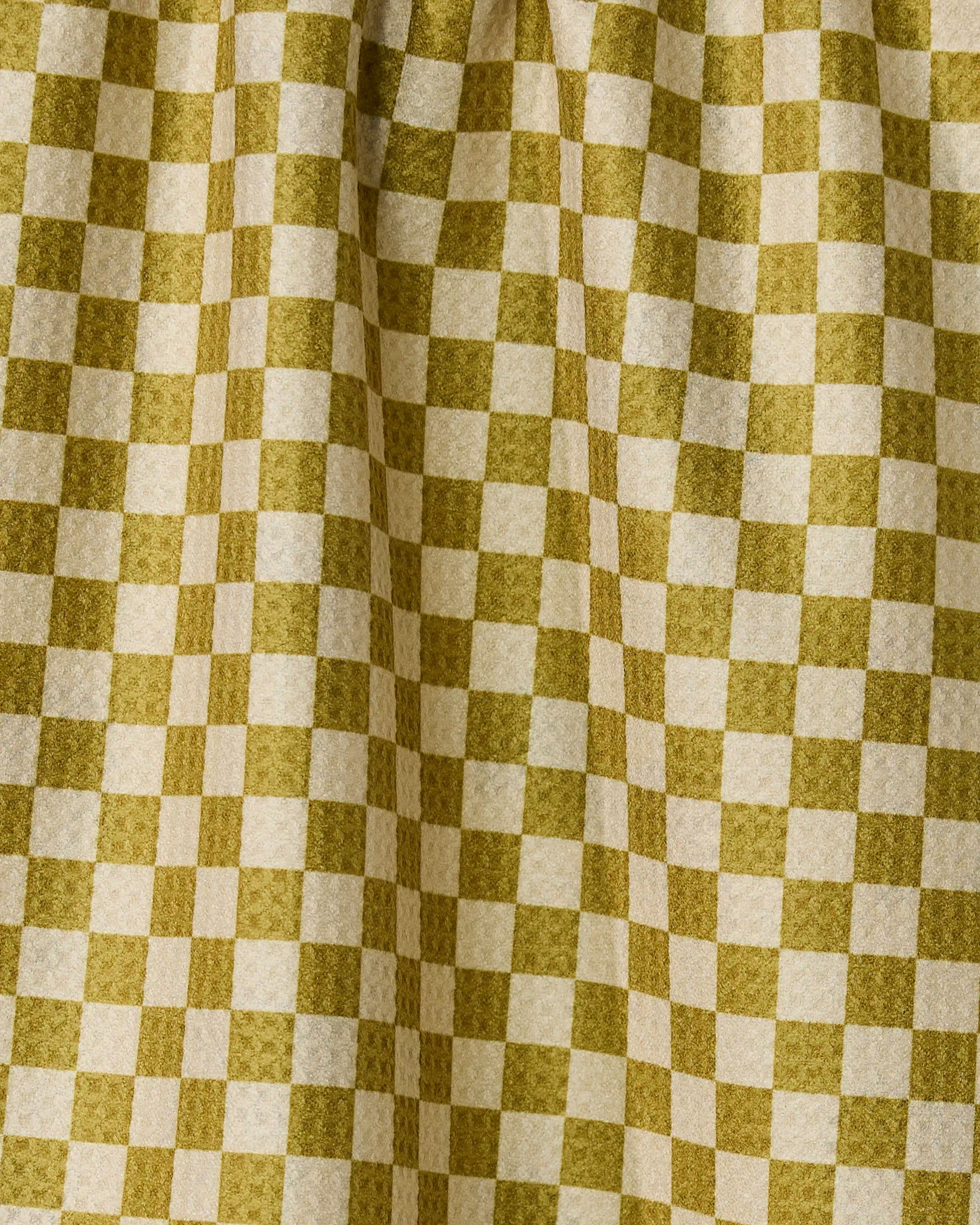 The Zebra Way by Geometry features yellow and cream checkered fabric with soft folds and depth. This double-sided tea towel is both stylish and practical, making it a perfect addition to your kitchen.