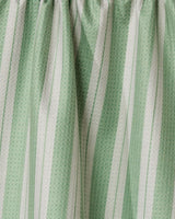 Close-up of Geometrys Pistachio recycled kitchen towel, featuring green and white vertical stripes in varying widths and a subtle texture, gathered at the top.