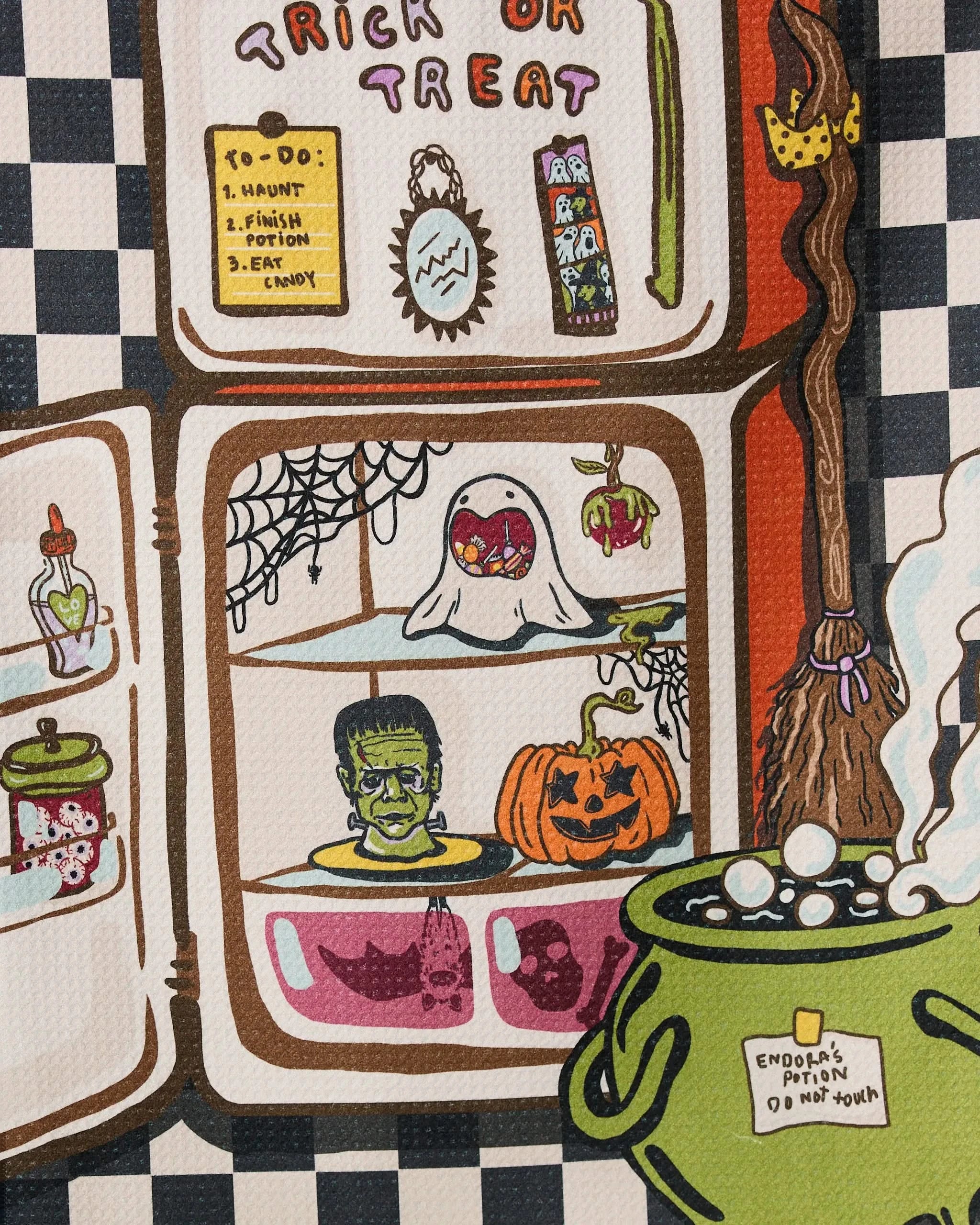 The Spooky Roommates towel by Geometry features a Halloween-themed fridge and bubbling cauldron on a checkered background—perfect for adding an eco-friendly, festive touch to your kitchen or tea area this season.