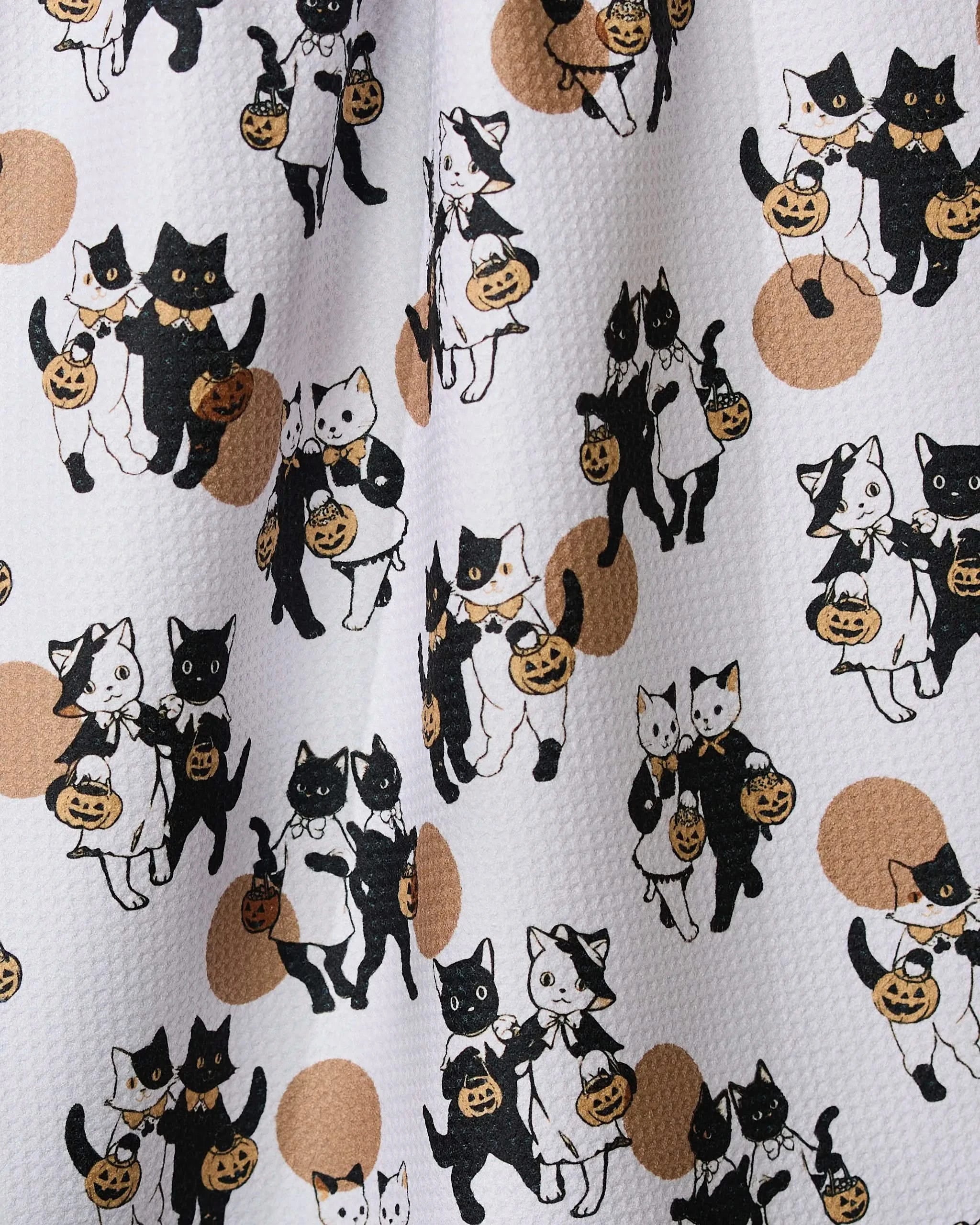 Halloween Date by Geometry features a playful pattern of black and white cartoon cats with pumpkin baskets and witch hats on a white textured background with brown dots—perfect for a quick-drying tea towel made from recycled materials.