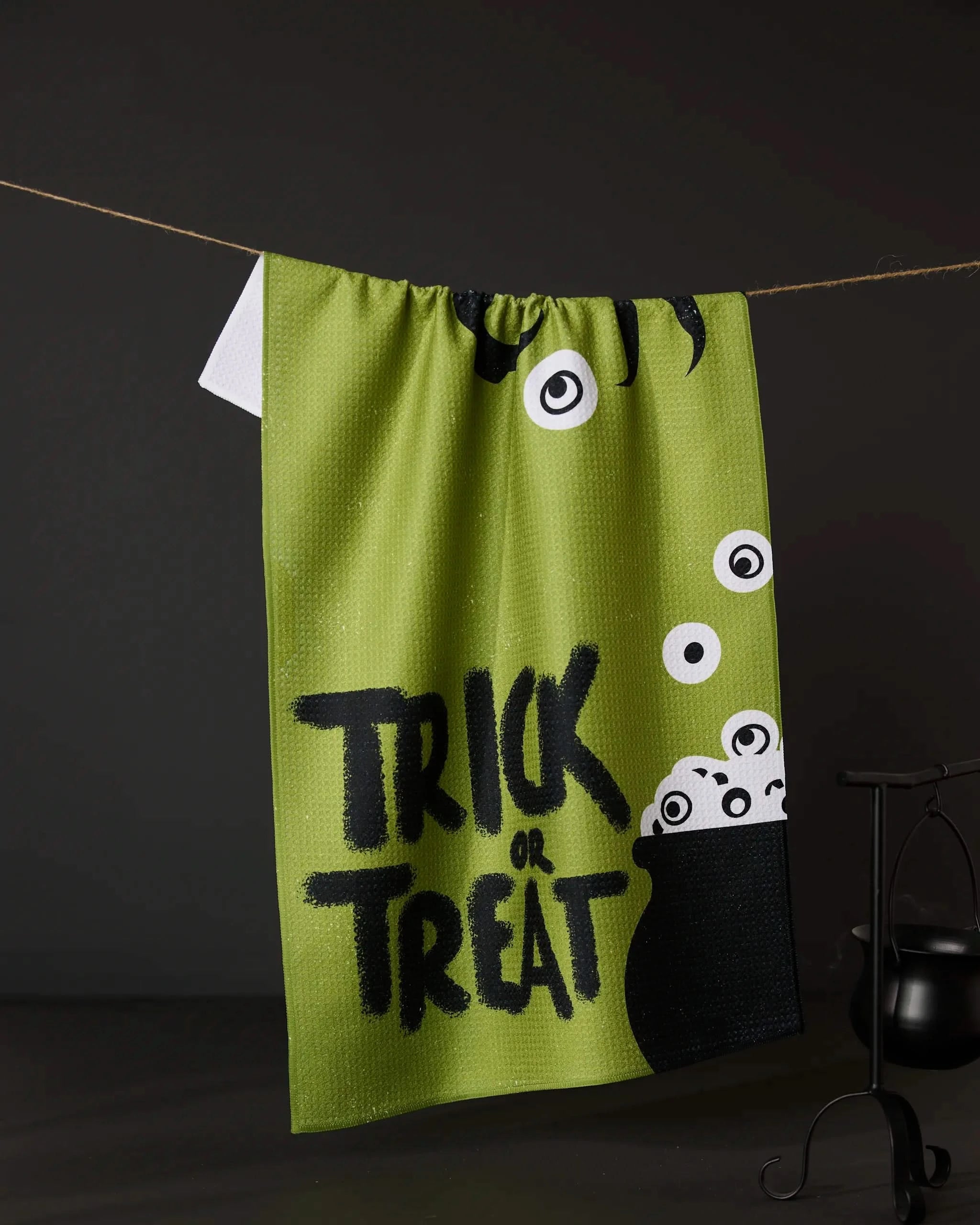The Geometry Tricky Treats ultra-absorbent towel features “Trick or Treat” in black, cartoon eyes, and a bubbling cauldron on green fabric—perfect for adding festive Halloween charm and function to your home.