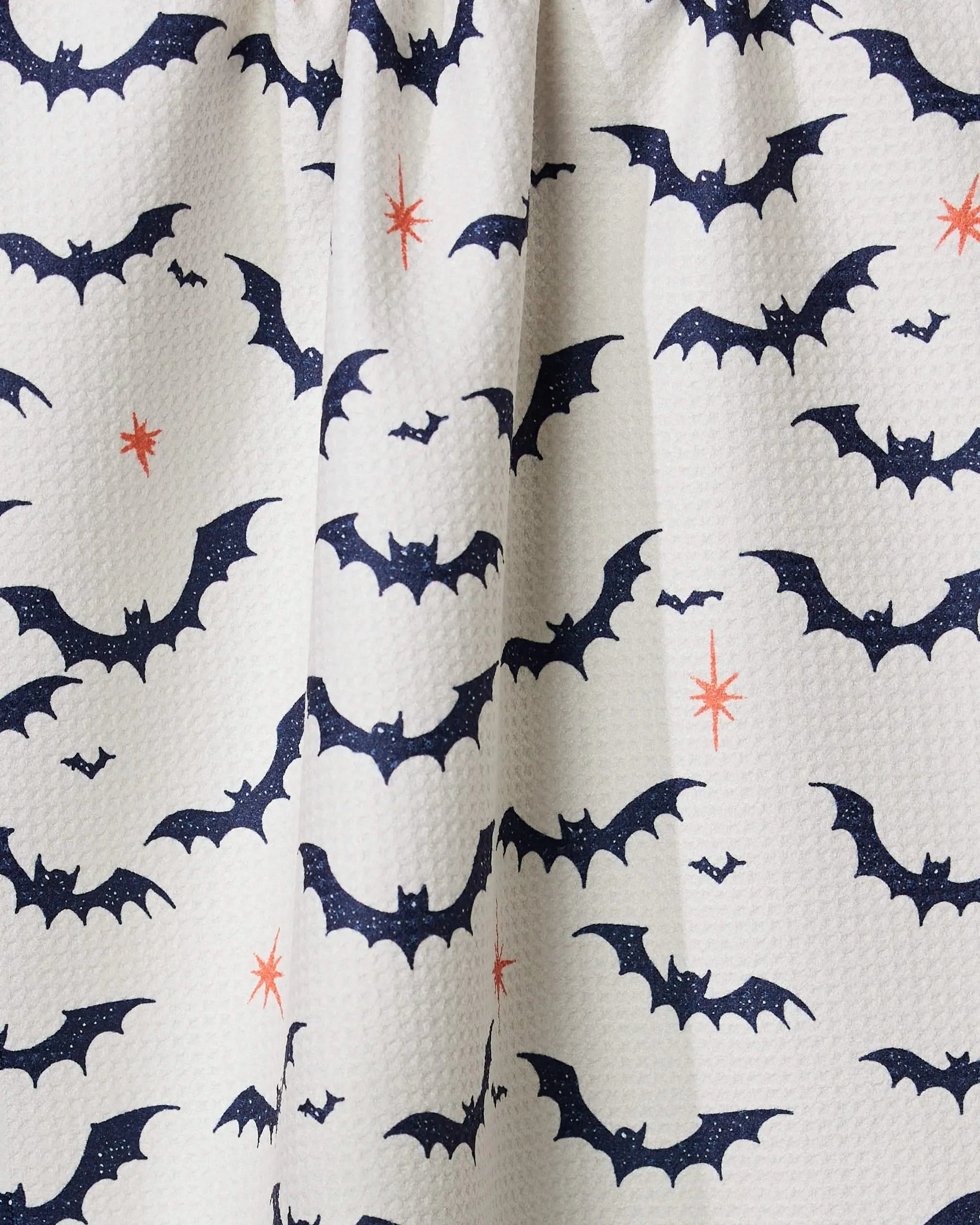 The Geometry Midnight Friends White dish towel features a white fabric with navy blue bats and orange stars, offering a quick-drying, festive Halloween-themed design thats perfect for your kitchen.