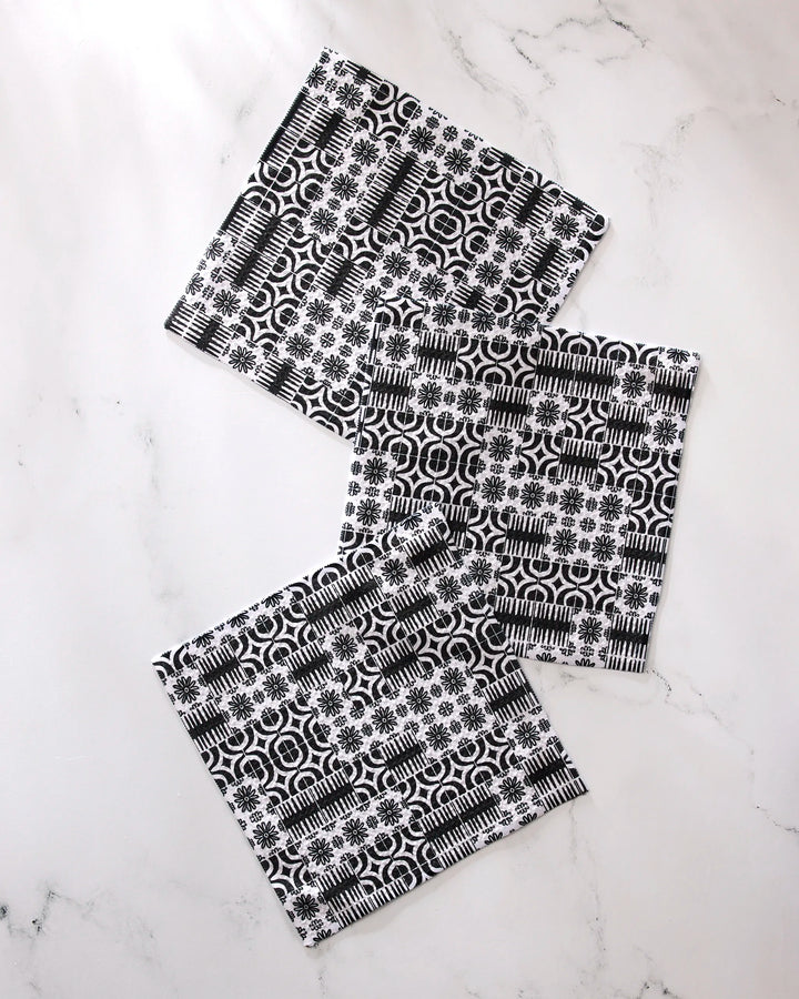 Three super-absorbent GEOMETRY Bohemian Mosaic dishcloths with black and white geometric and floral patterns are displayed on a white marble surface.