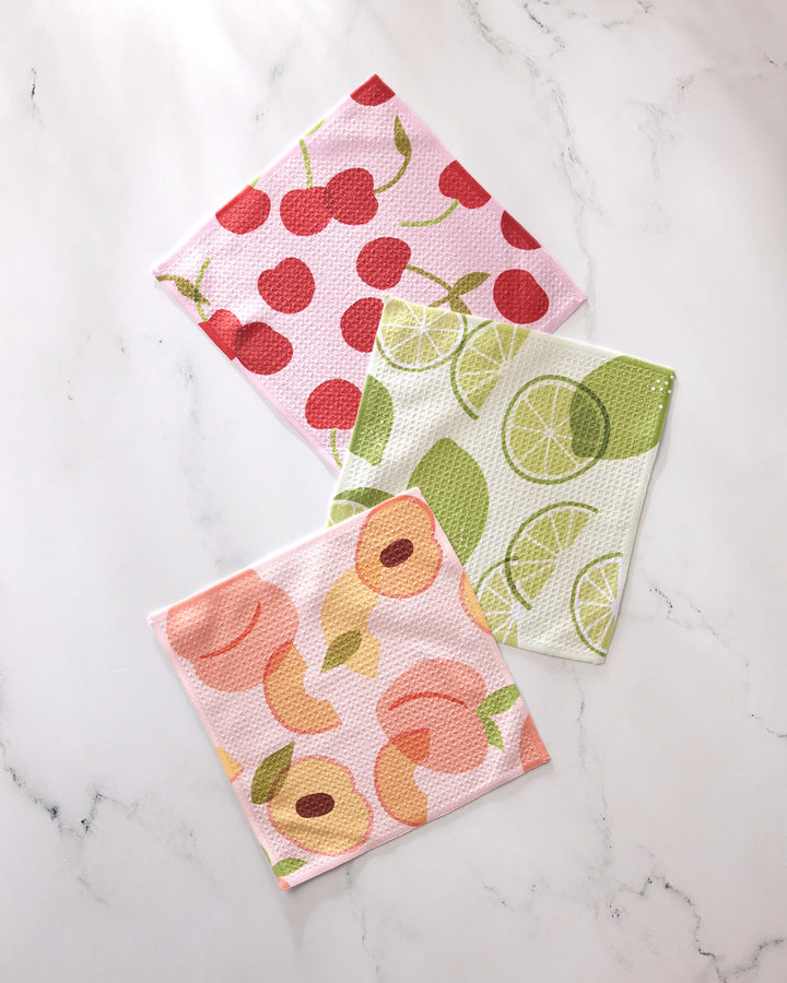 The GEOMETRY Fruit Fun set includes three super-absorbent dishcloths featuring red cherries, green lime slices, and pink and yellow peaches—combining vibrant charm with everyday practicality.
