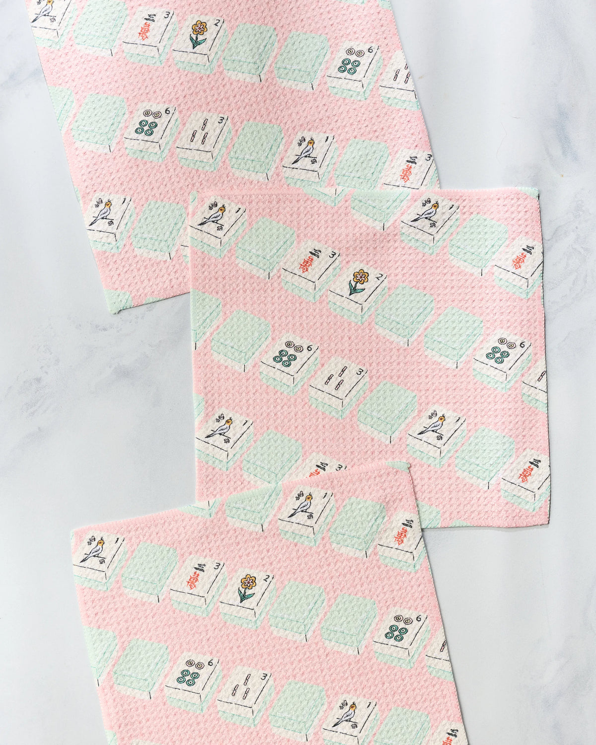 Three Geometry Tile Parade super-absorbent dishcloths with a pink background and a repeating pattern of mahjong tiles.