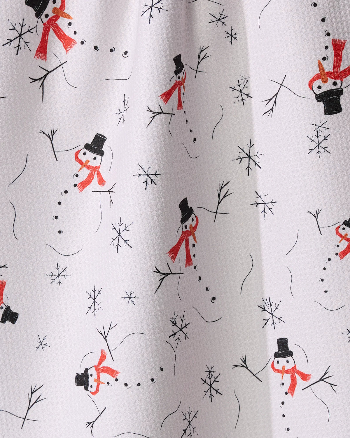 Chill Chums by Geometry: A white textured recycled kitchen towel with hand-drawn snowmen in black hats, red scarves, stick arms, black buttons, and scattered snowflakes—all oriented in various directions.