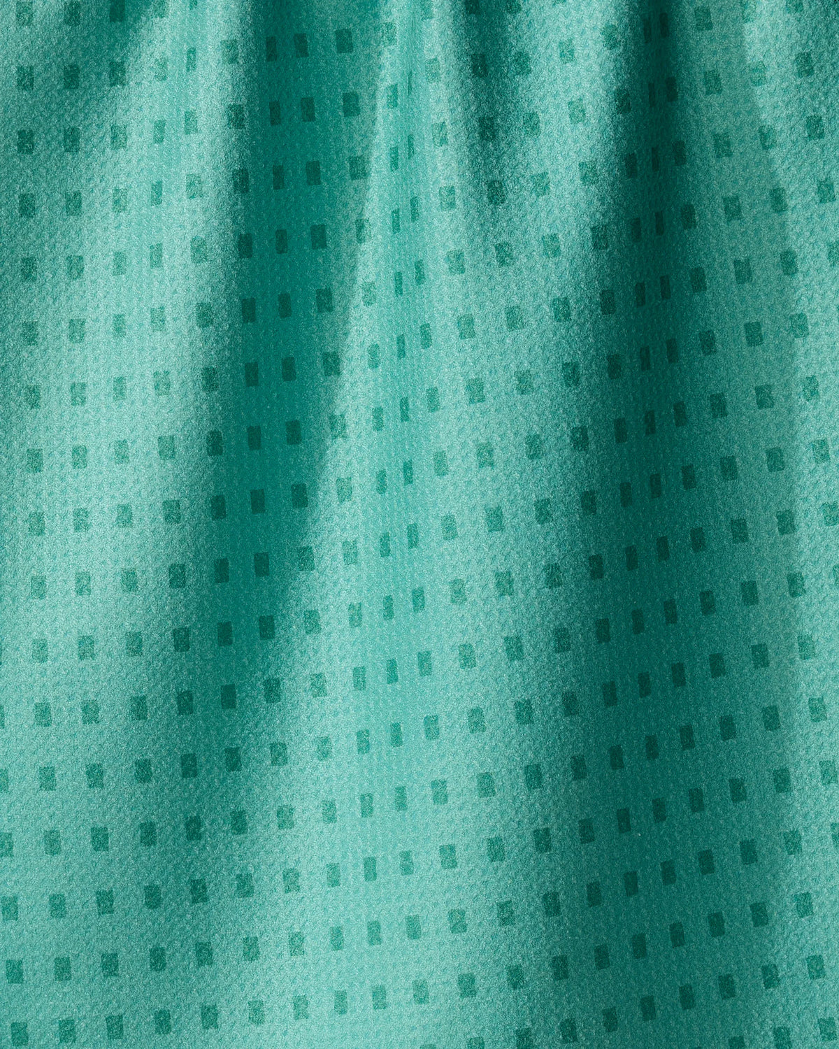Geometry Confetti Tiles teal kitchen towel featuring a repeating pattern of small, dark squares.