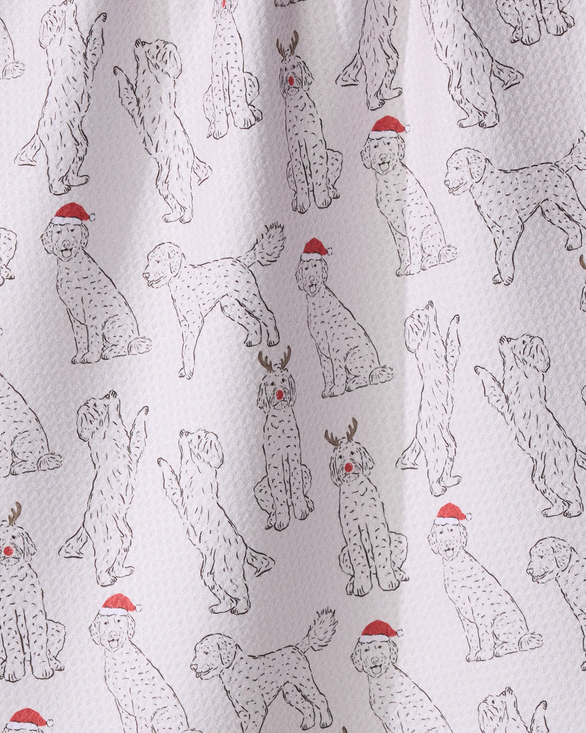 The Geometry Festive Doodles kitchen towel features doodle-style dogs wearing Santa hats or reindeer antlers, adding eco-friendly holiday cheer to your kitchen.