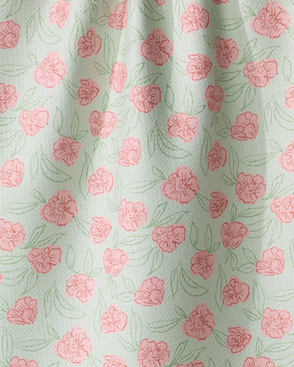 Geometry Lucky Bloom recycled kitchen towel featuring a pattern of pink hand-drawn flowers and green leaves on a pale green background.