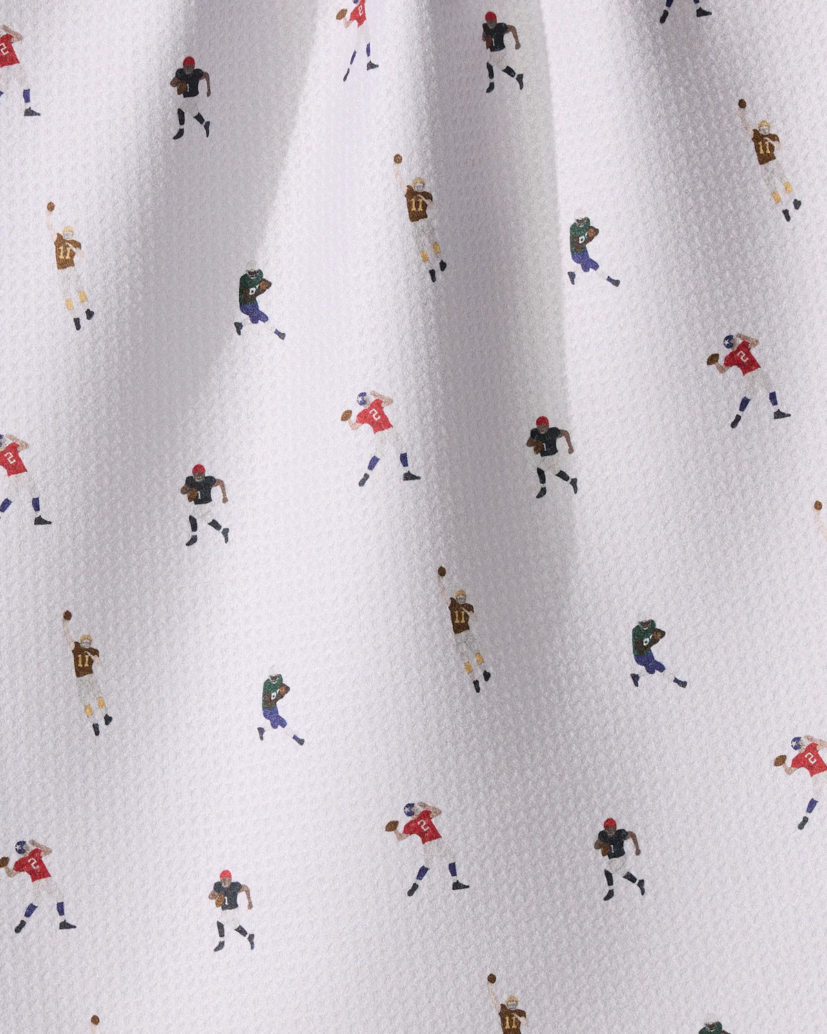 Roster tea towel in white fabric with a repeating pattern of small football players in various uniforms running and throwing footballs.