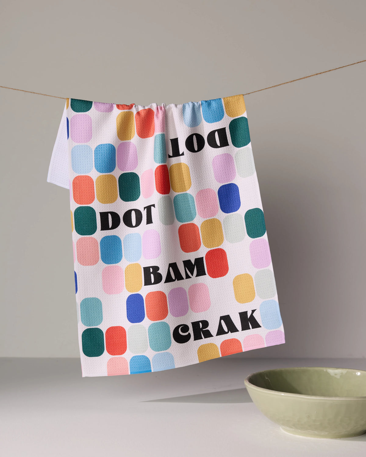Geometry Tile Talk tea towel featuring a pattern of colorful rounded rectangles and the words DOT, BAM, and CRAK printed in black.