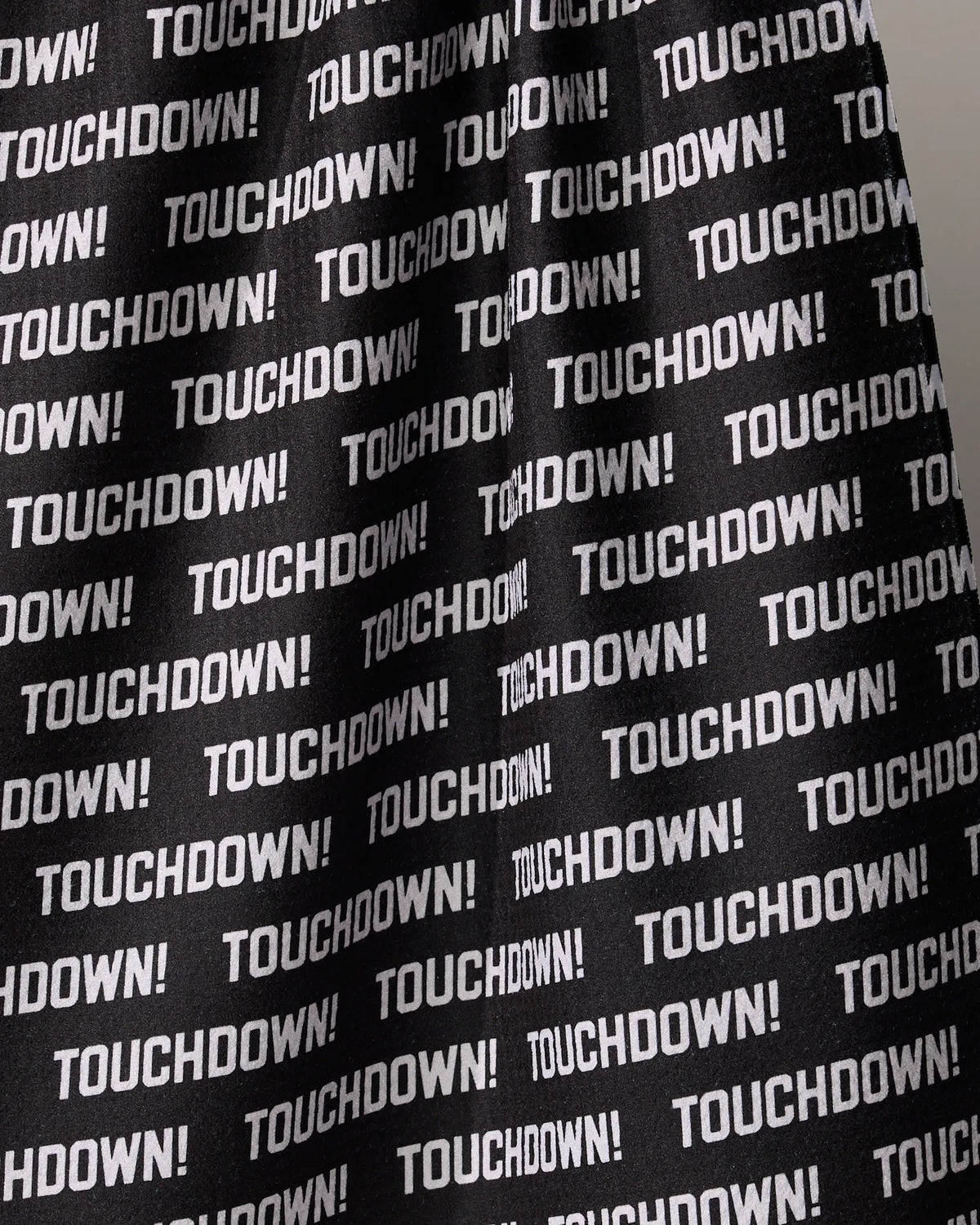 Black recycled Geometry Touchdown kitchen towel patterned with a repeating white TOUCHDOWN! print in a sans-serif font.