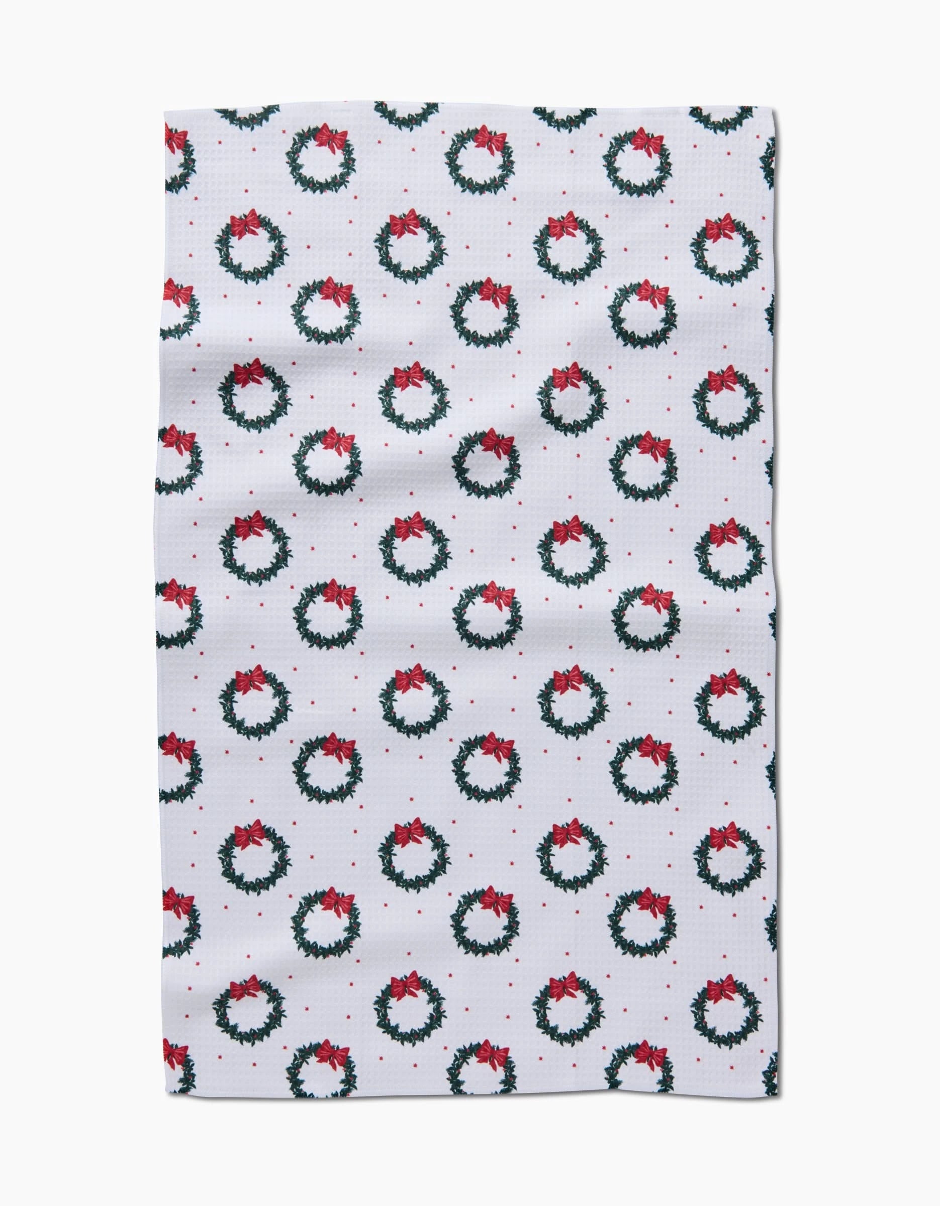 The Ash Cascade Bow Wreath Luxe Hand Towel is made from white cloth with small green Christmas wreaths, red bows, and berries. Featuring Geoweave technology, it’s stylish and quick-drying—perfect for daily use.