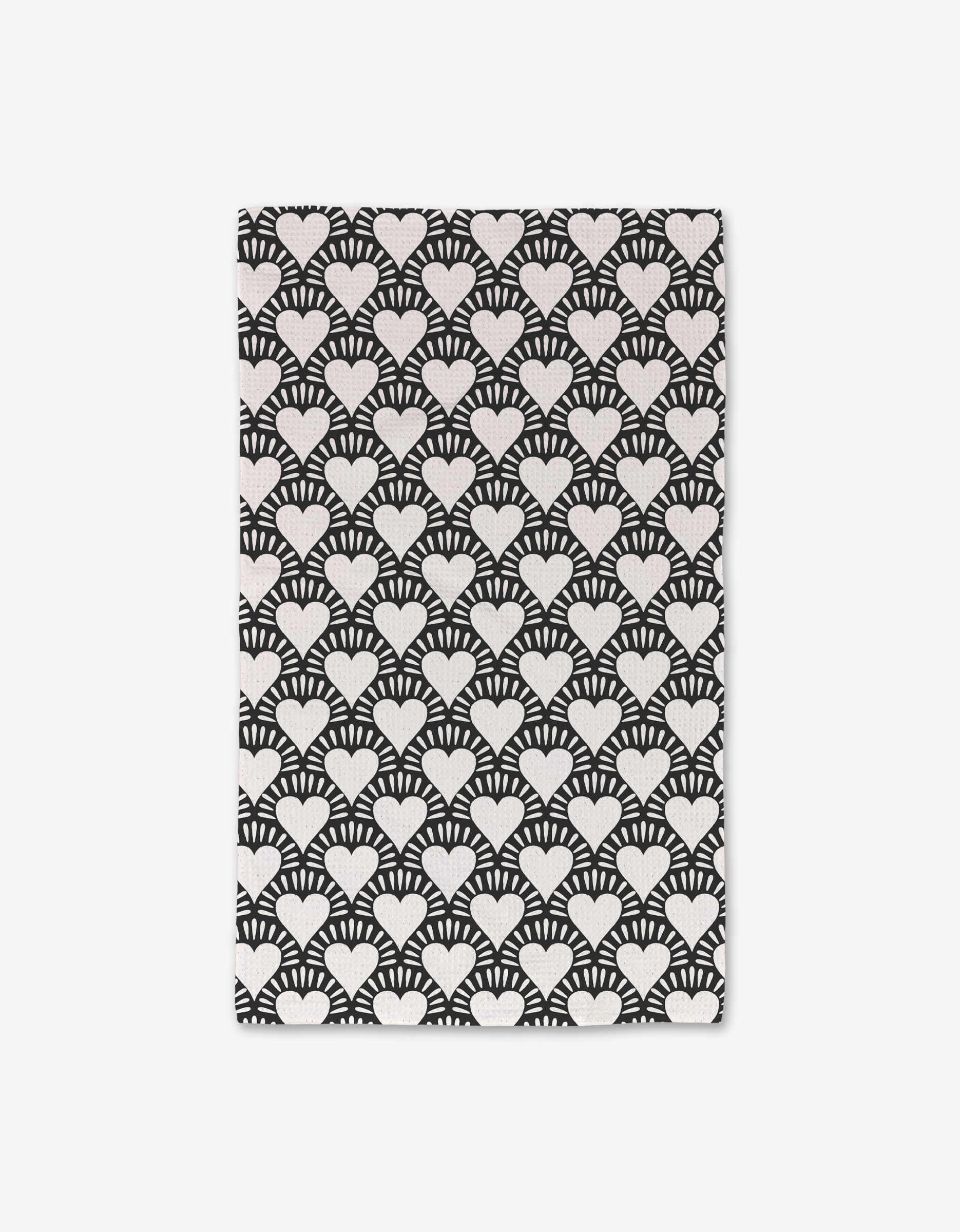The Heartthrob Onyx rug by Charlie Rowan Designs features white heart shapes with radiating lines on a black rectangular background. Made from recycled materials, its shown on a plain white surface.