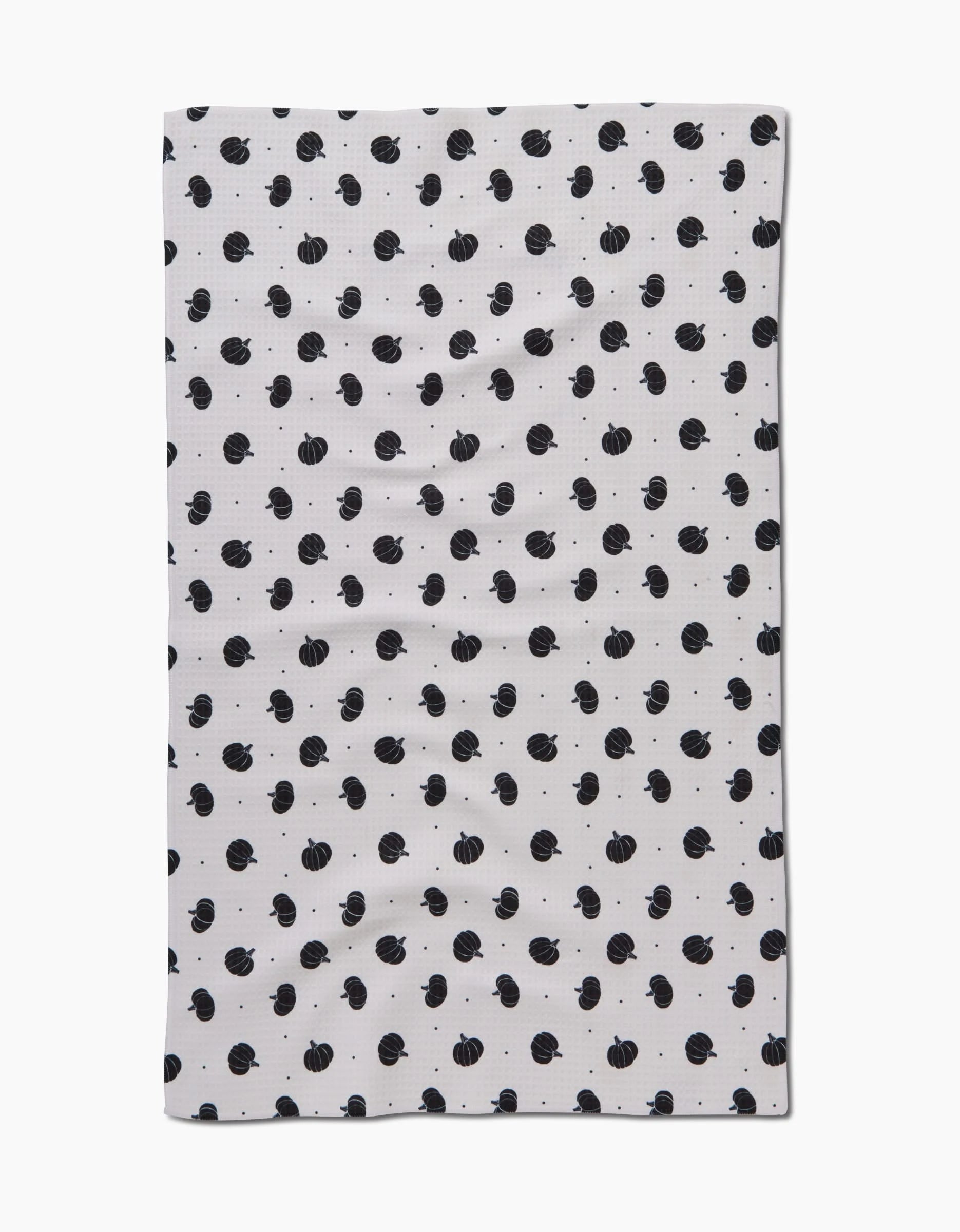 The Ash Cascade Midnight Pumpkin hand towel is a white rectangle with small black pumpkins in a repeating pattern, made with ultra-absorbent Geoweave technology for superior performance.