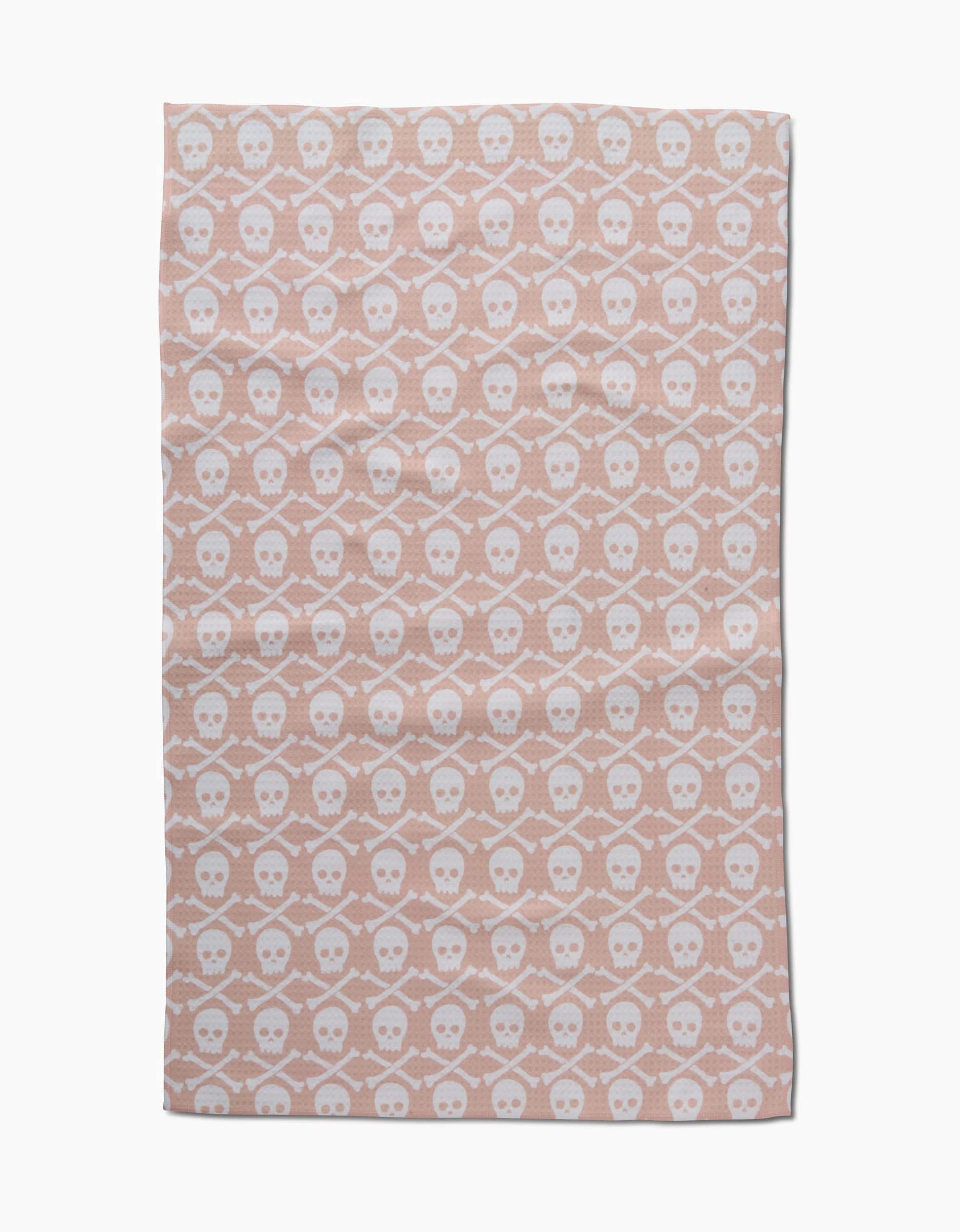 The Skull Bones Natural Luxe Hand Towel by Hufton Studio features a pink background with white skulls and crossbones in hexagons. Rectangular, ultra-absorbent, and quick-drying—ideal for everyday use.