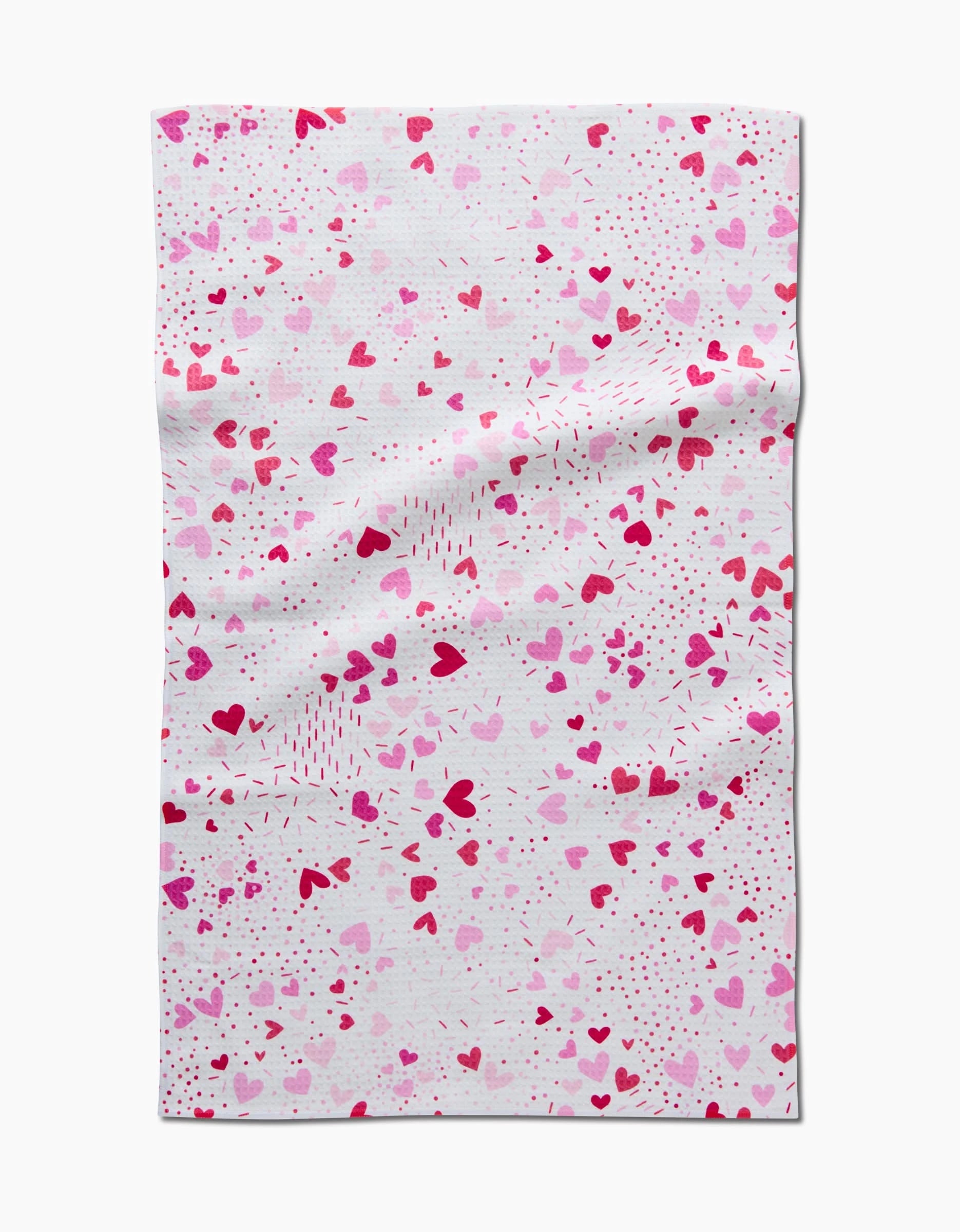 The Sprinkled With Love Luxe Hand Towel by Rebecca Bobko is white with a pattern of pink and red hearts and multi-shade dots, featuring an ultra-absorbent fabric with subtle wrinkles.