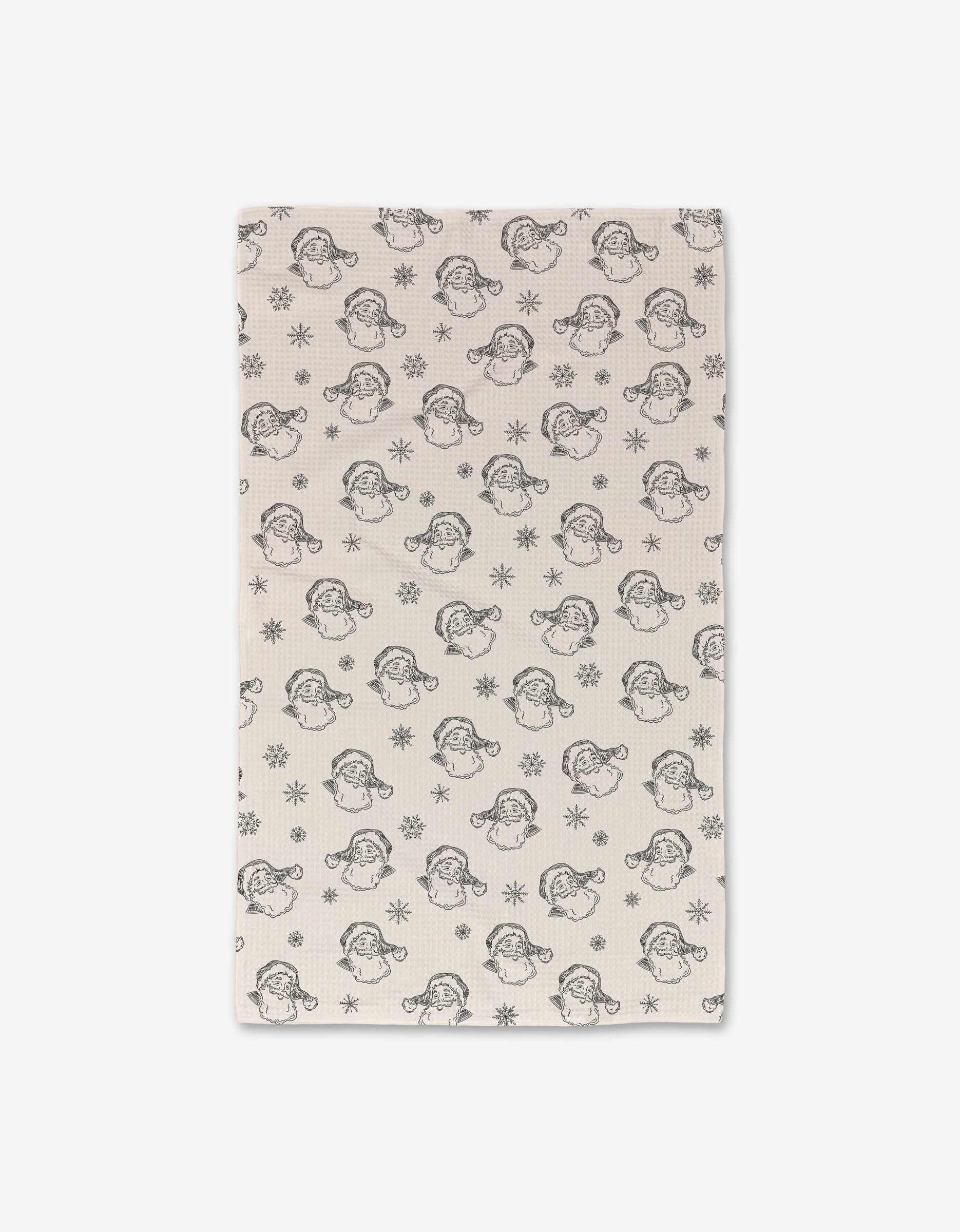 The Vintage Santa towel by Aubrey Fairchild is a white, ultra-absorbent kitchen towel with black line drawings of Santa faces and snowflakes—perfect for festive decor.